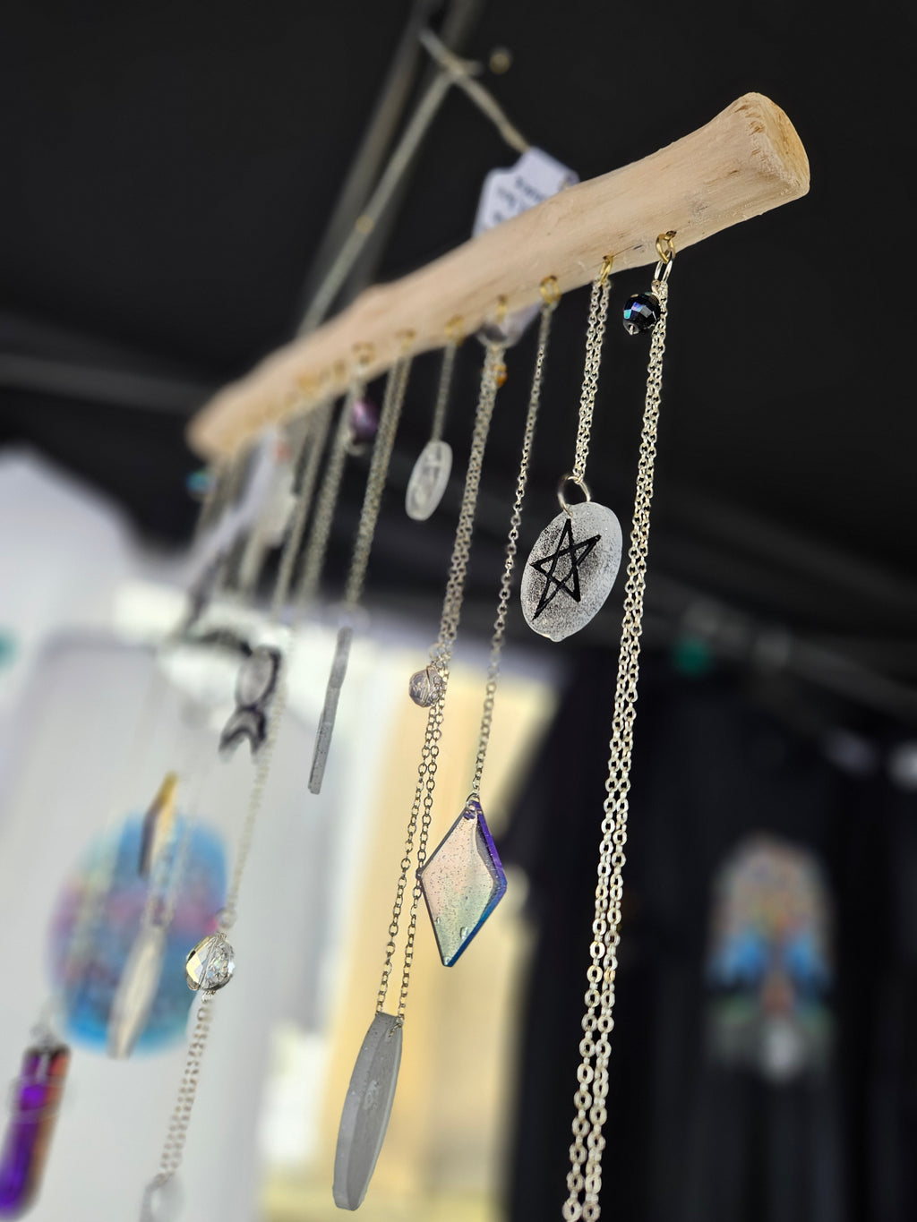 Witches wall hanging showing pentagram and crystals hanging from wood
