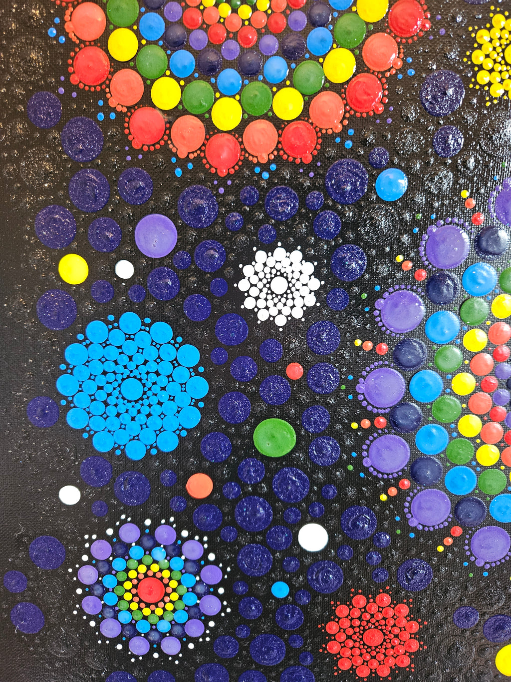 Colorful dot painting with various sizes mandala on a black background