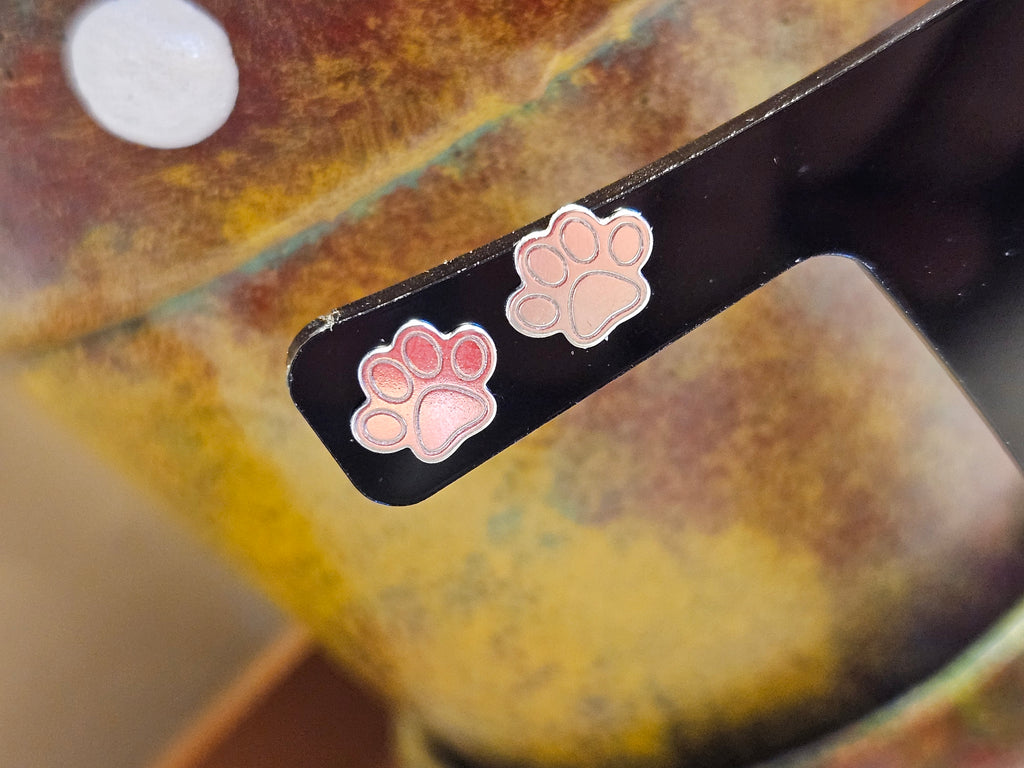 Close up of silver printed paw print stud earrings