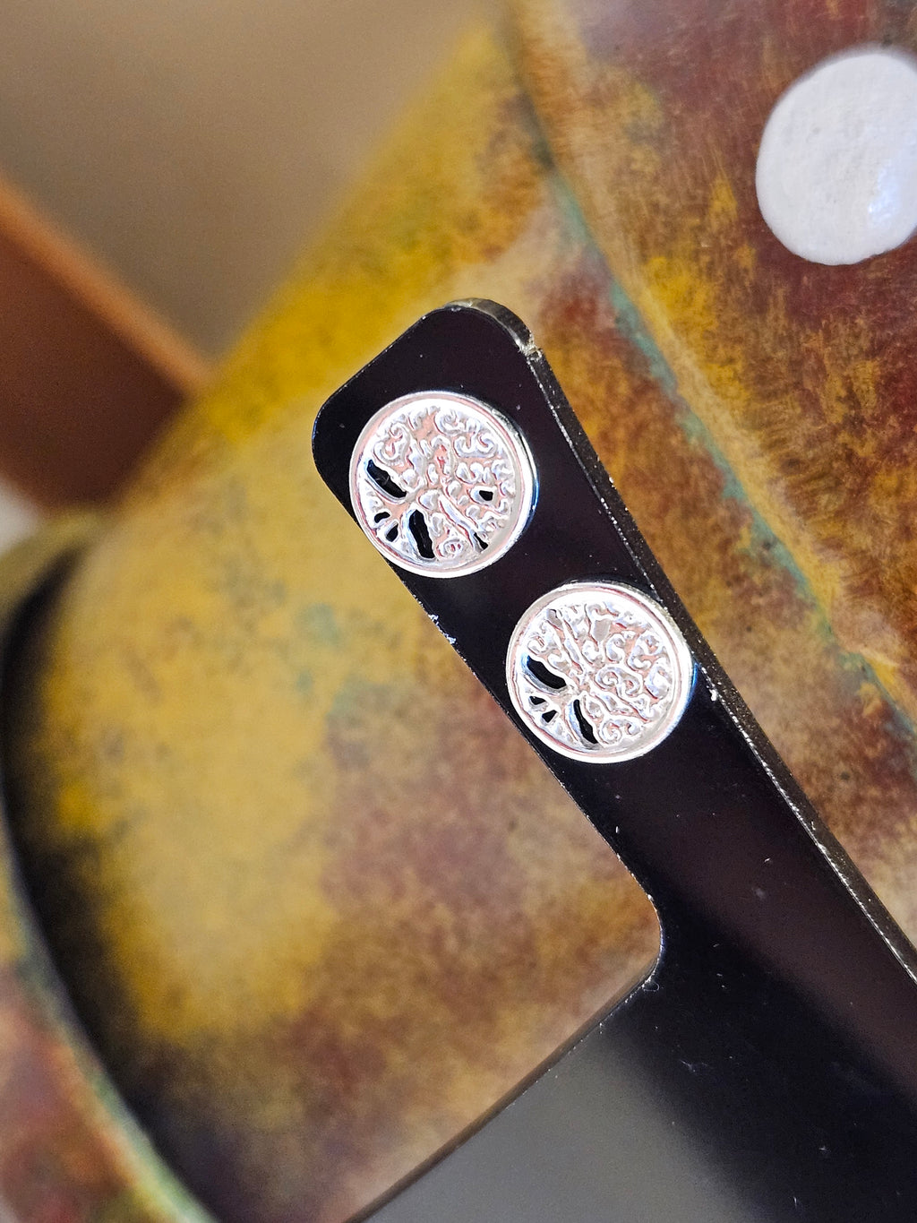 Close up of silver Tree Of Life stud earrings