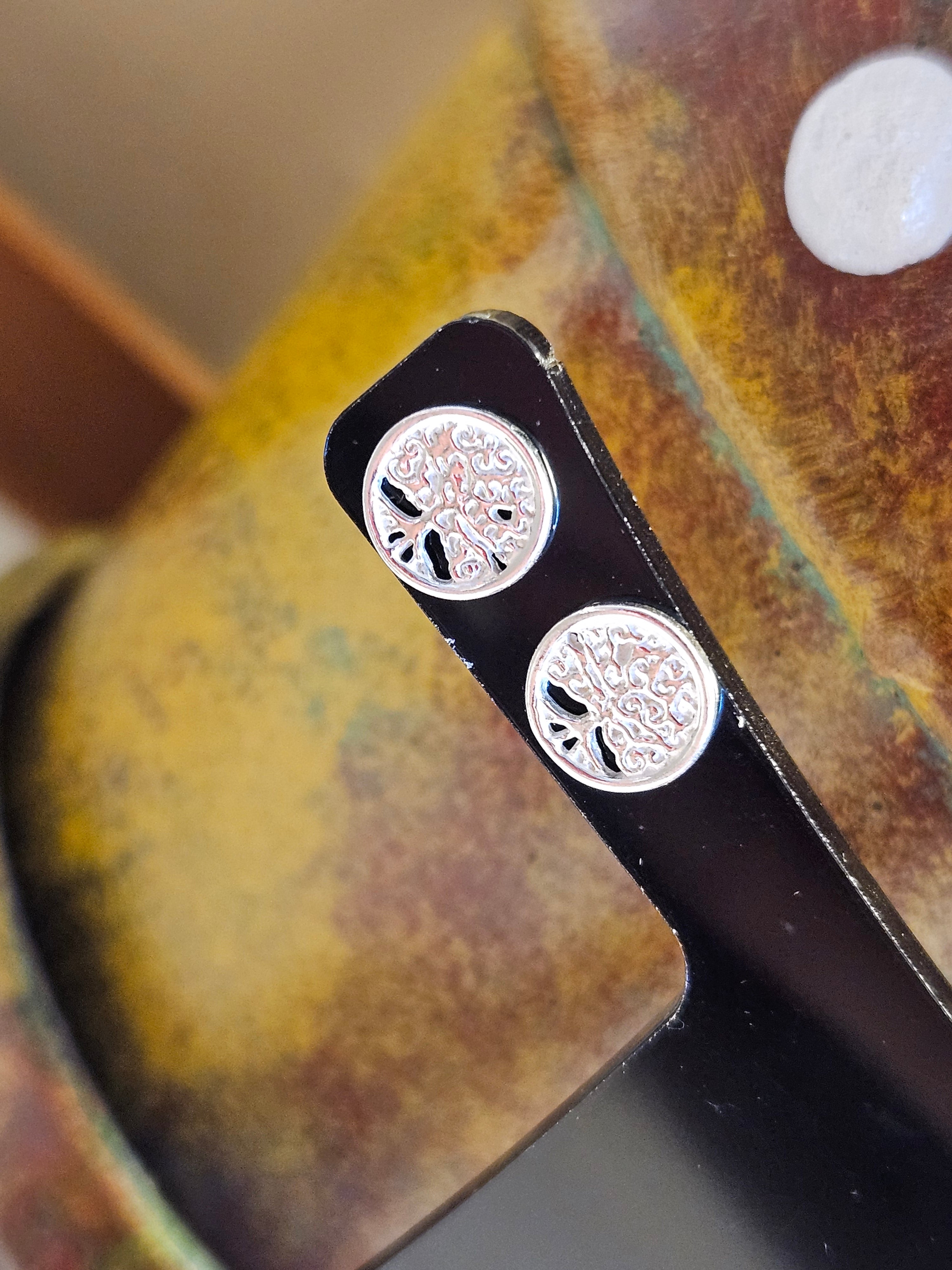 Close up of silver Tree Of Life stud earrings