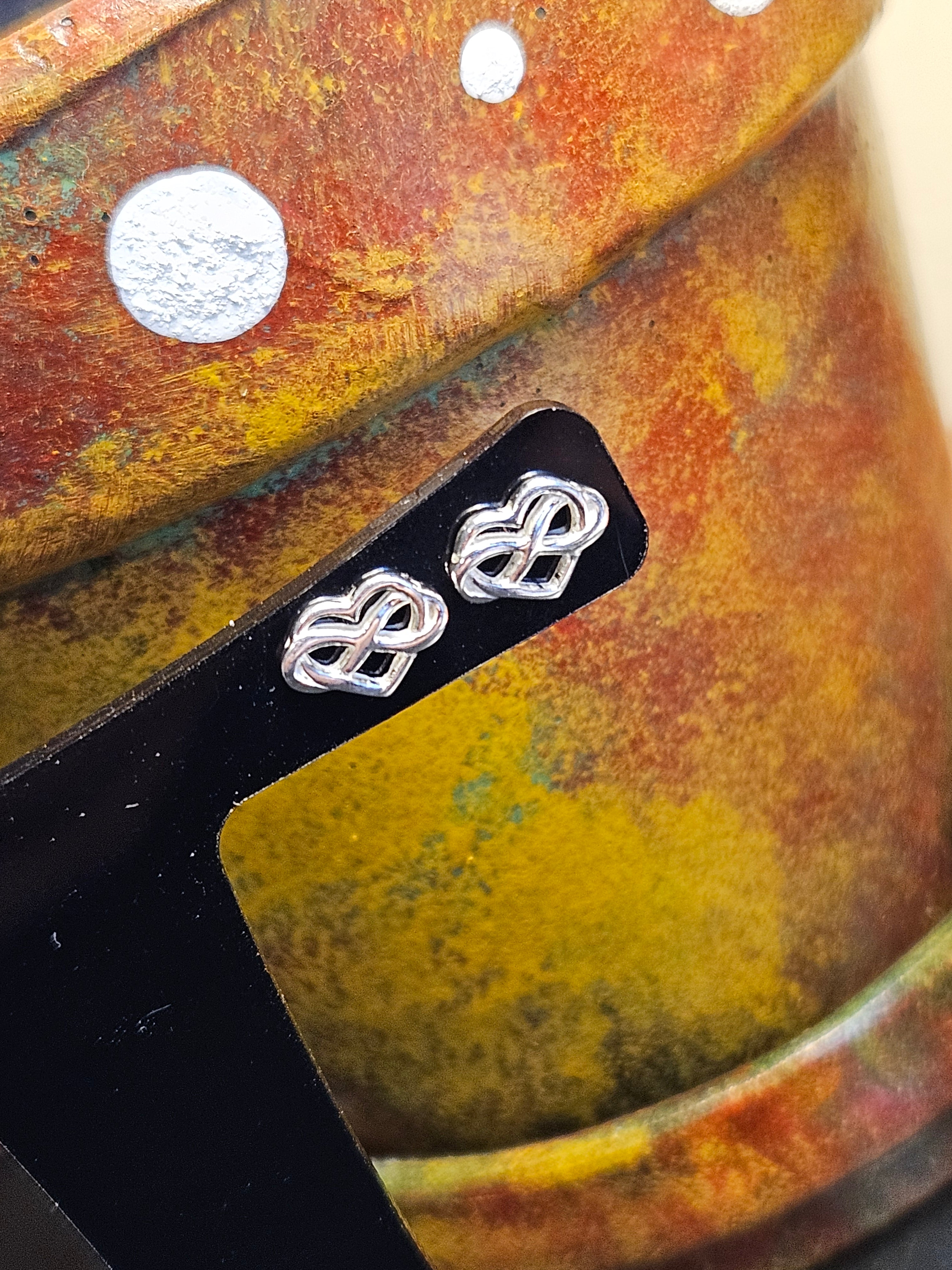 Close up of silver Infinity Heart stud earrings