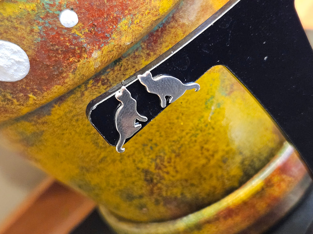 Close up of silver cat stud earrings