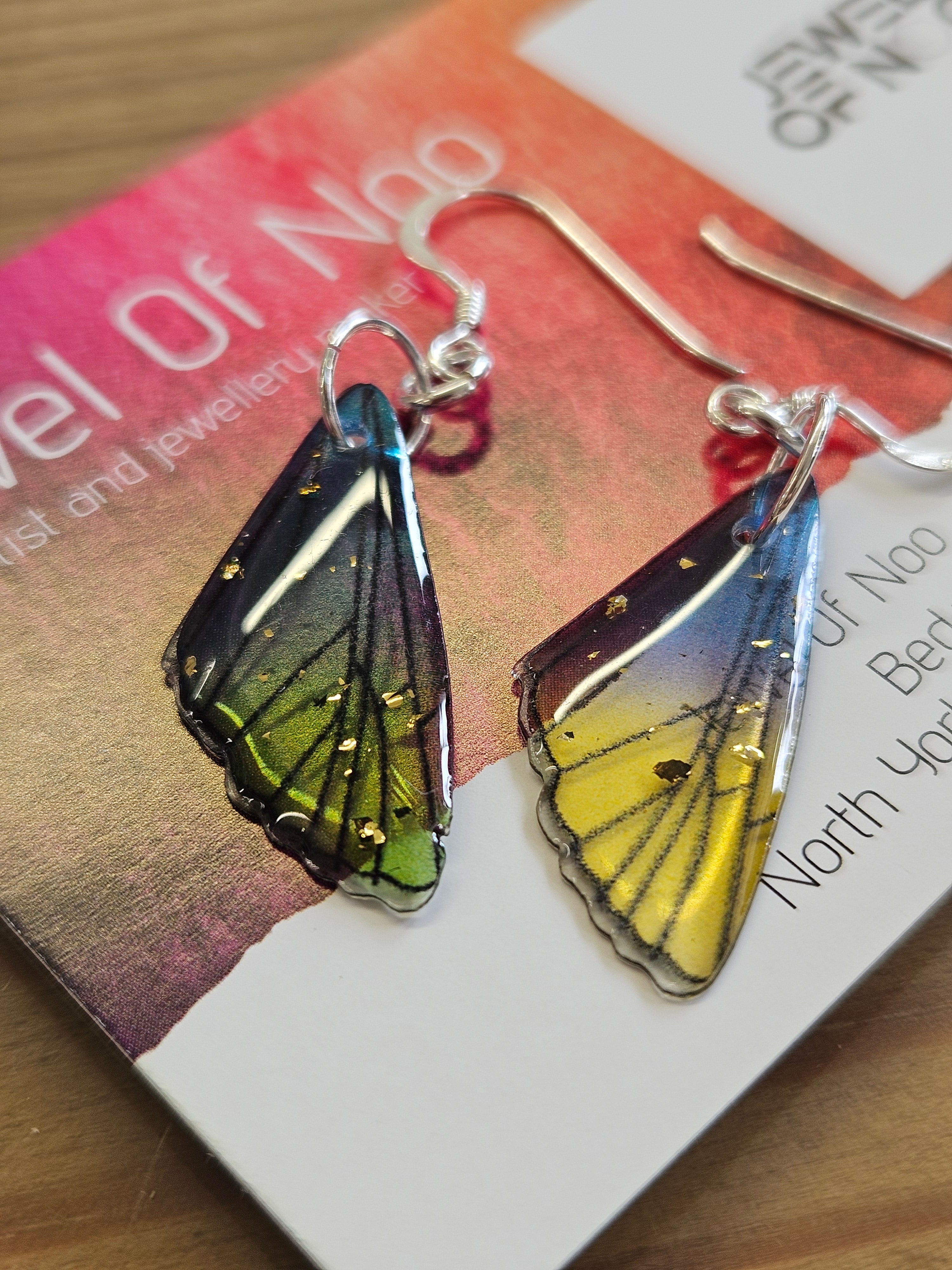 Fairy wing earrings on a business card