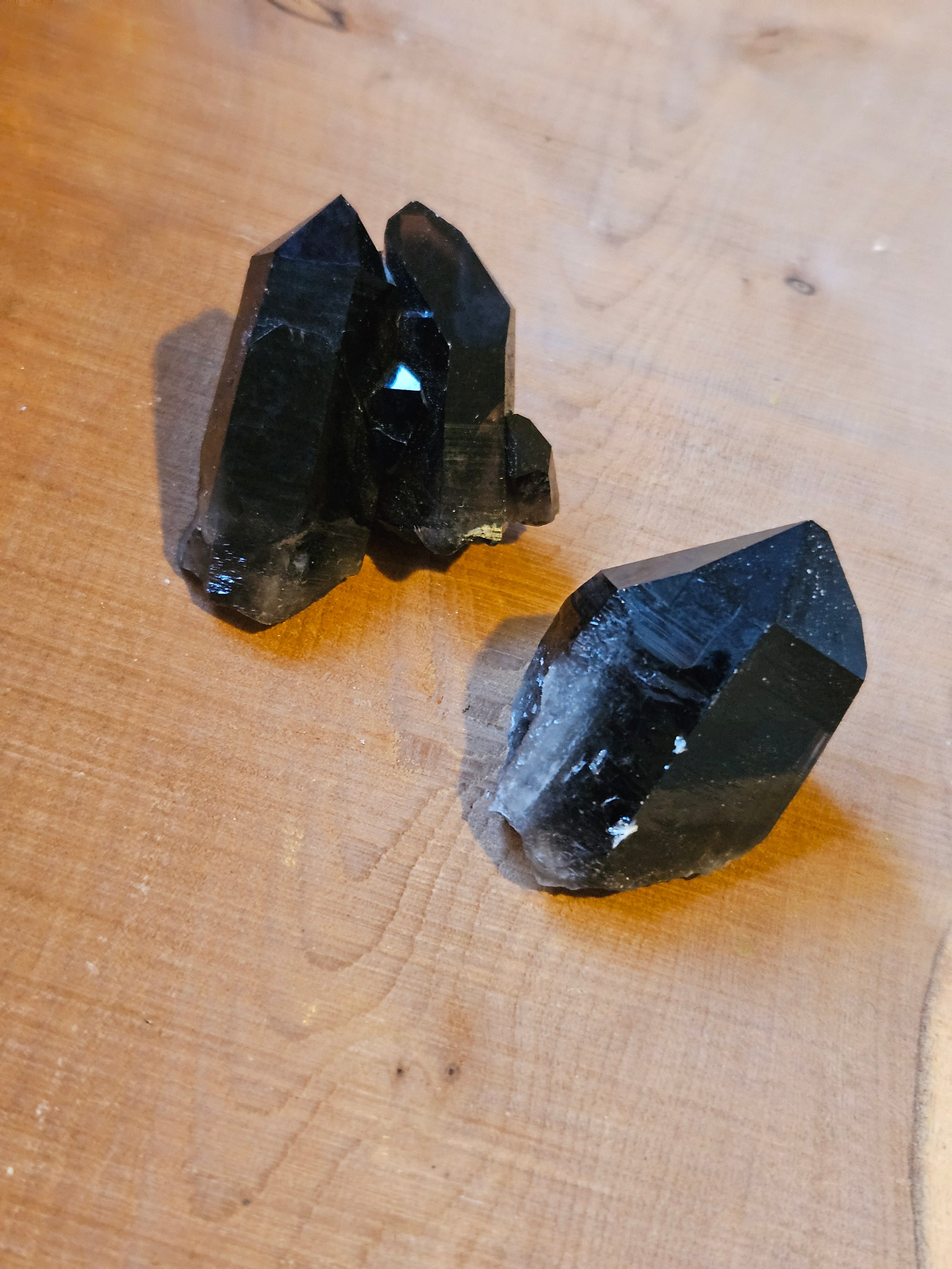 Two Smokey Quartz points on wooden board