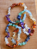 Gemstone chip chakra bracelets on a wooden board