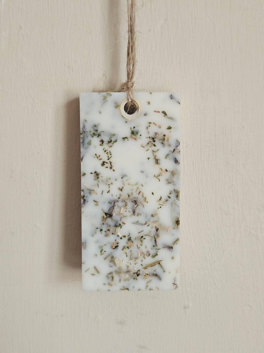 Rectangular scented pendant with natural ingredients on a white surface