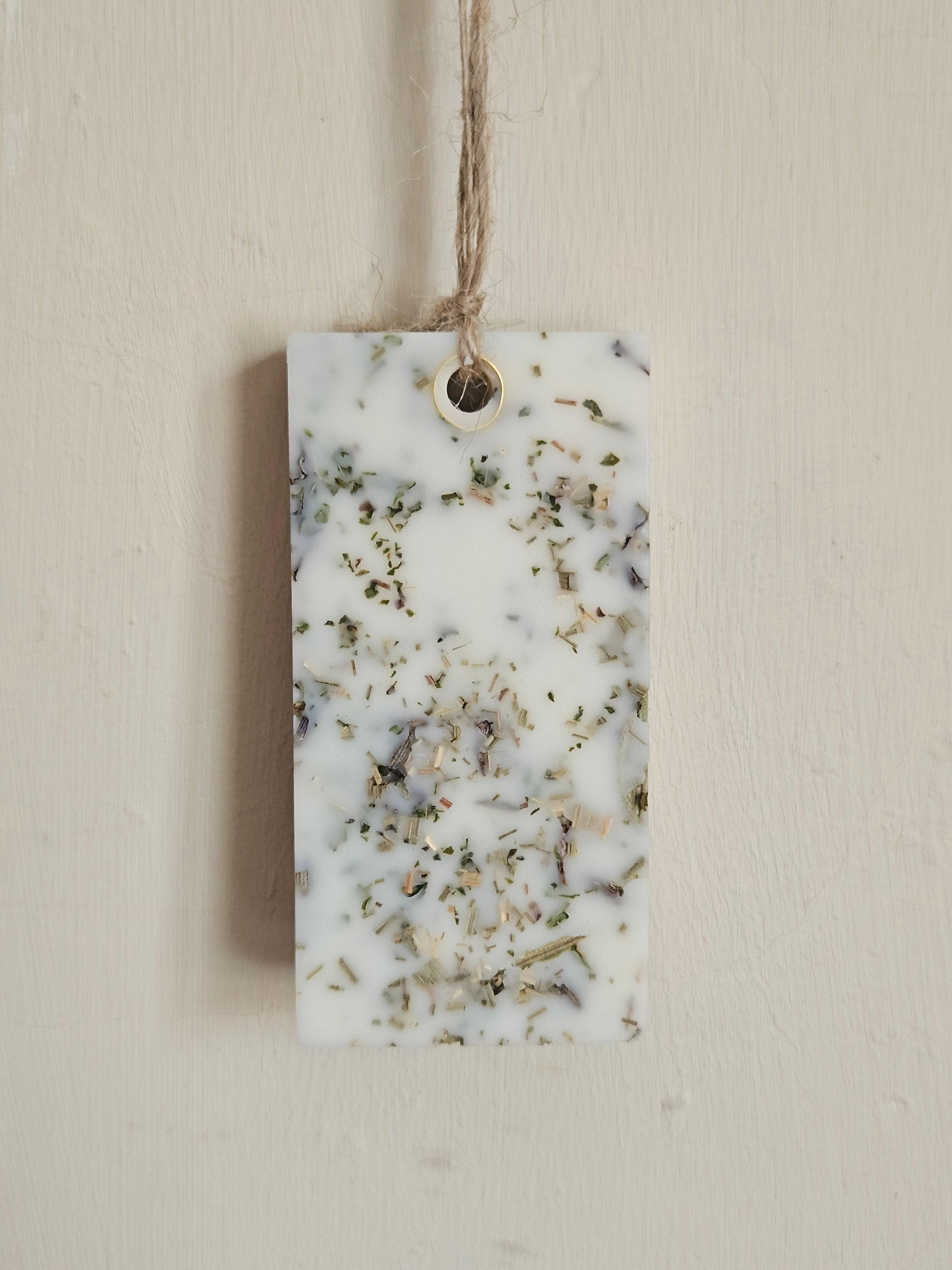Rectangular scented pendant with natural ingredients on a white surface
