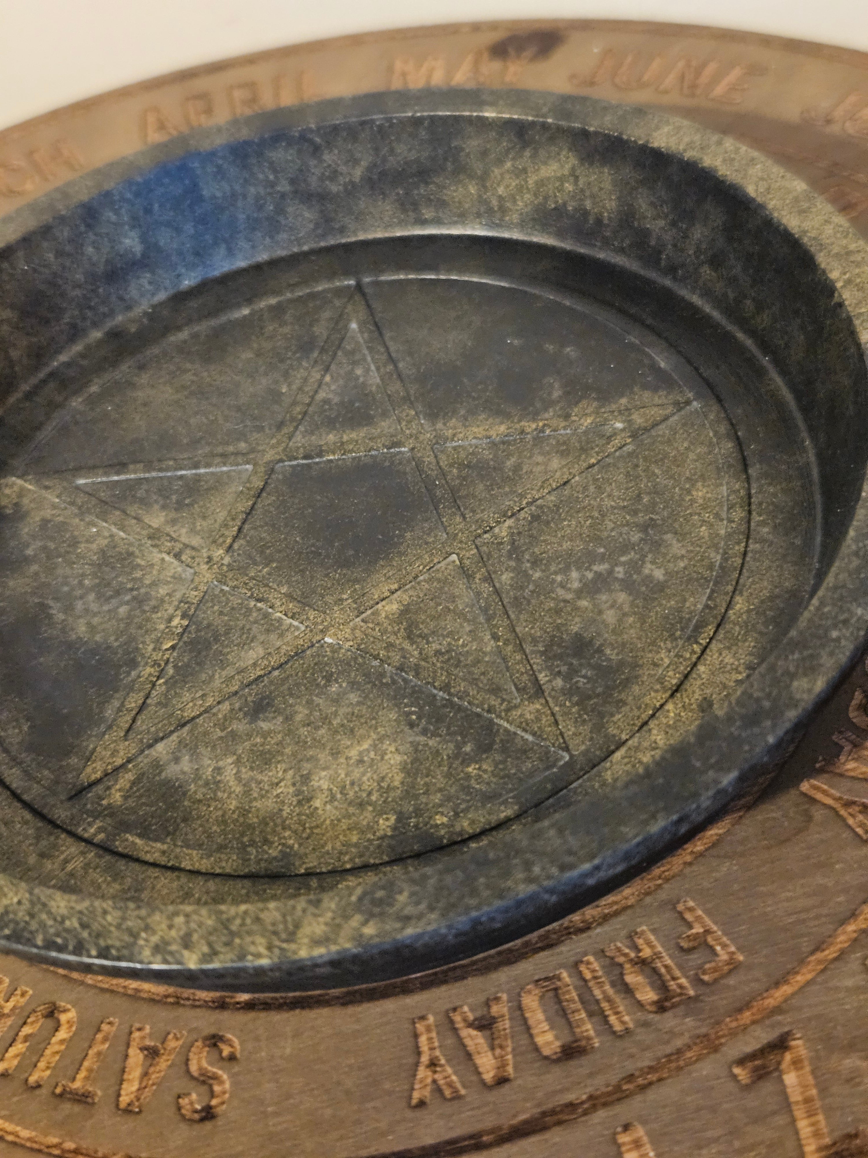 Close up of black and gold bowl with a pentagram