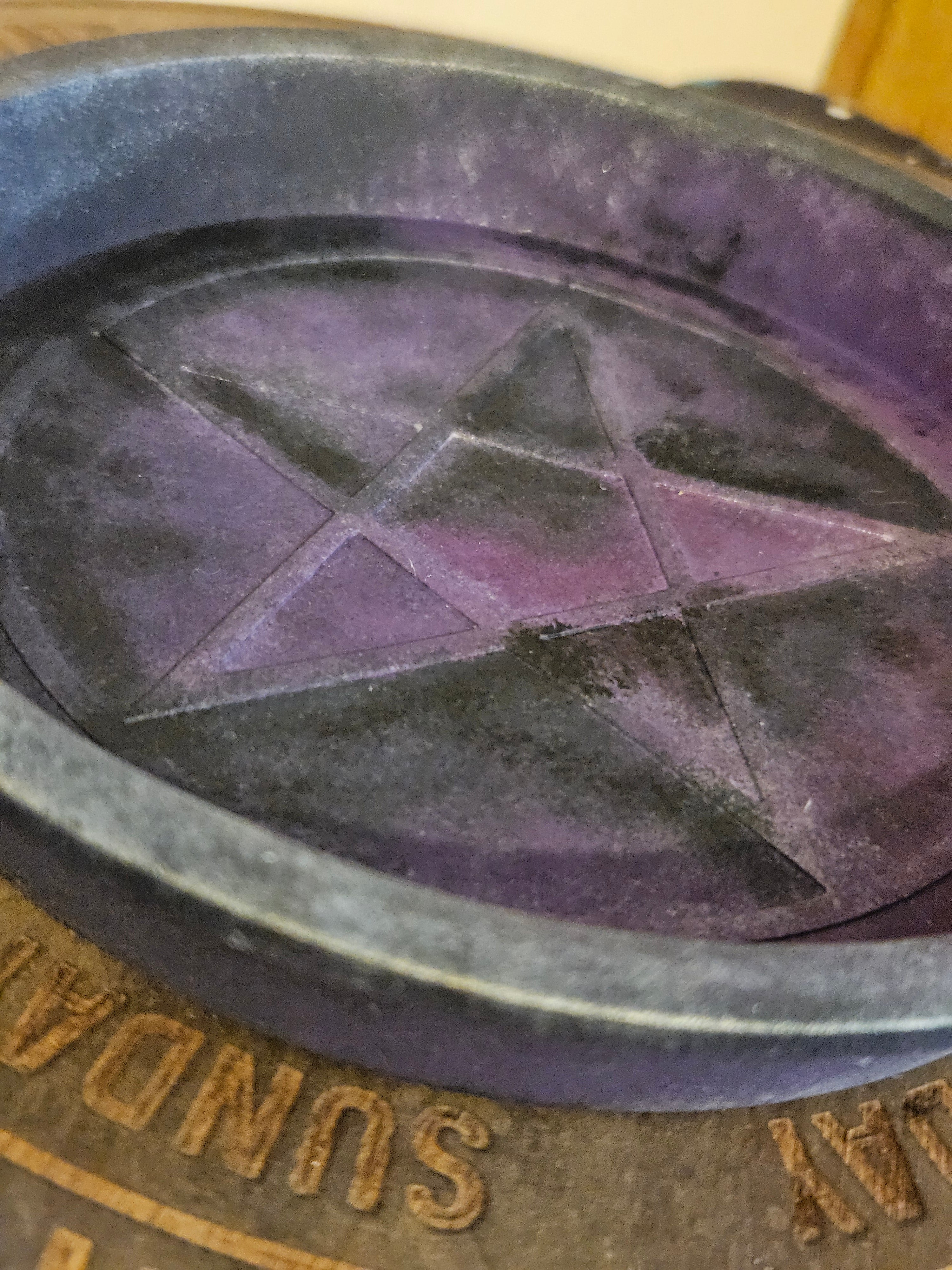 Close up of black and purple bowl with a pentagram
