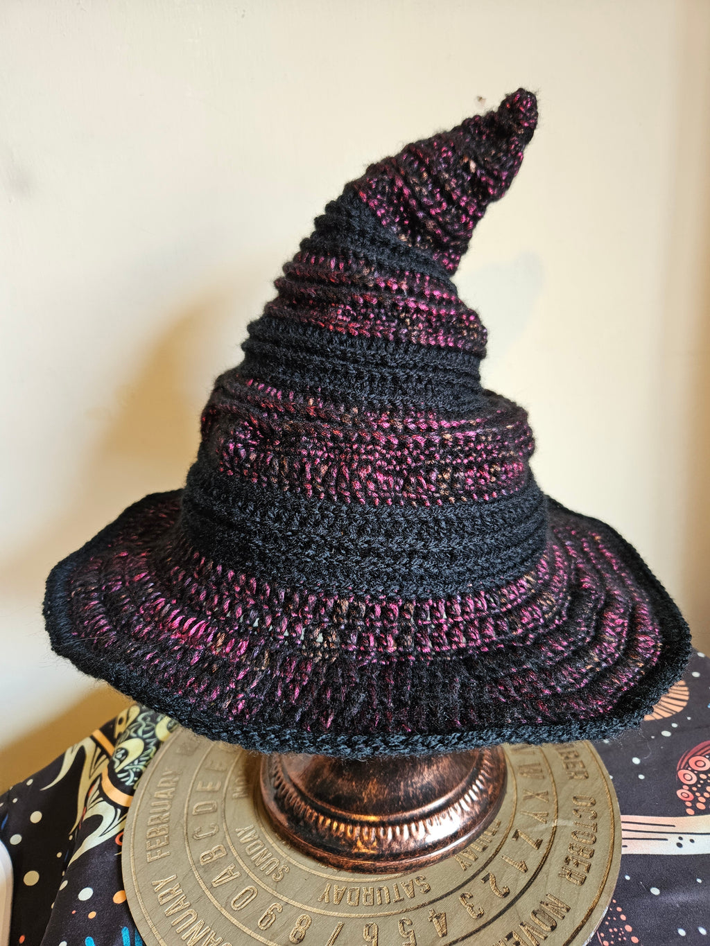 Knitted black and purple hat on a decorative object with a blurred background