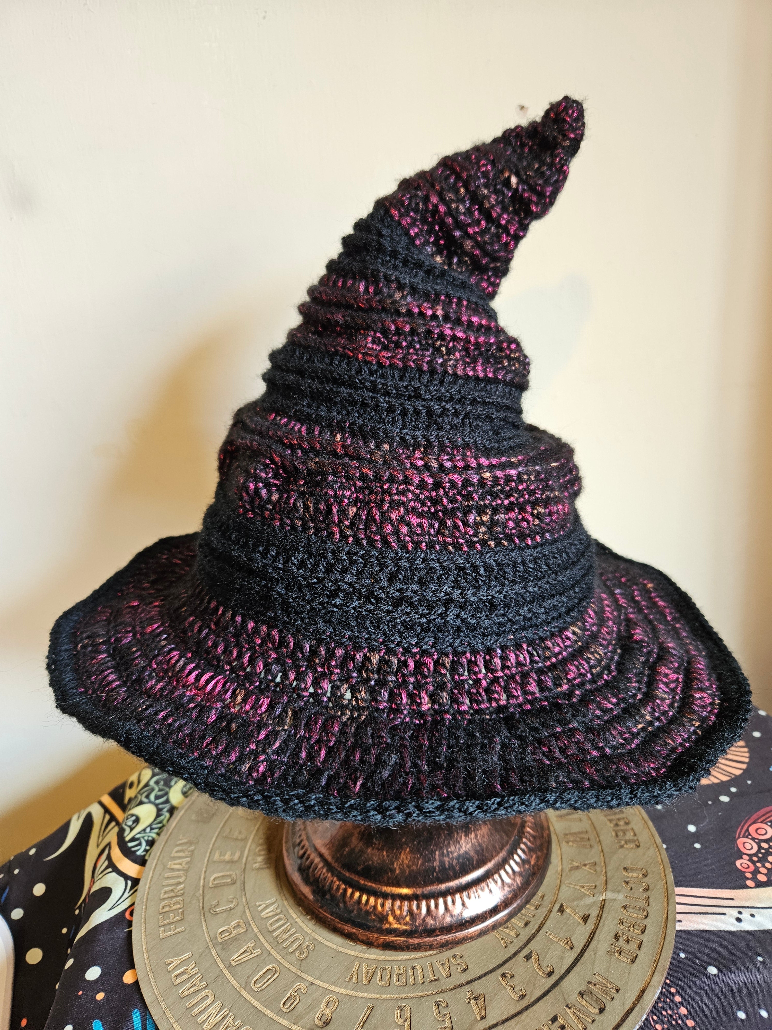 Knitted black and purple hat on a decorative object with a blurred background