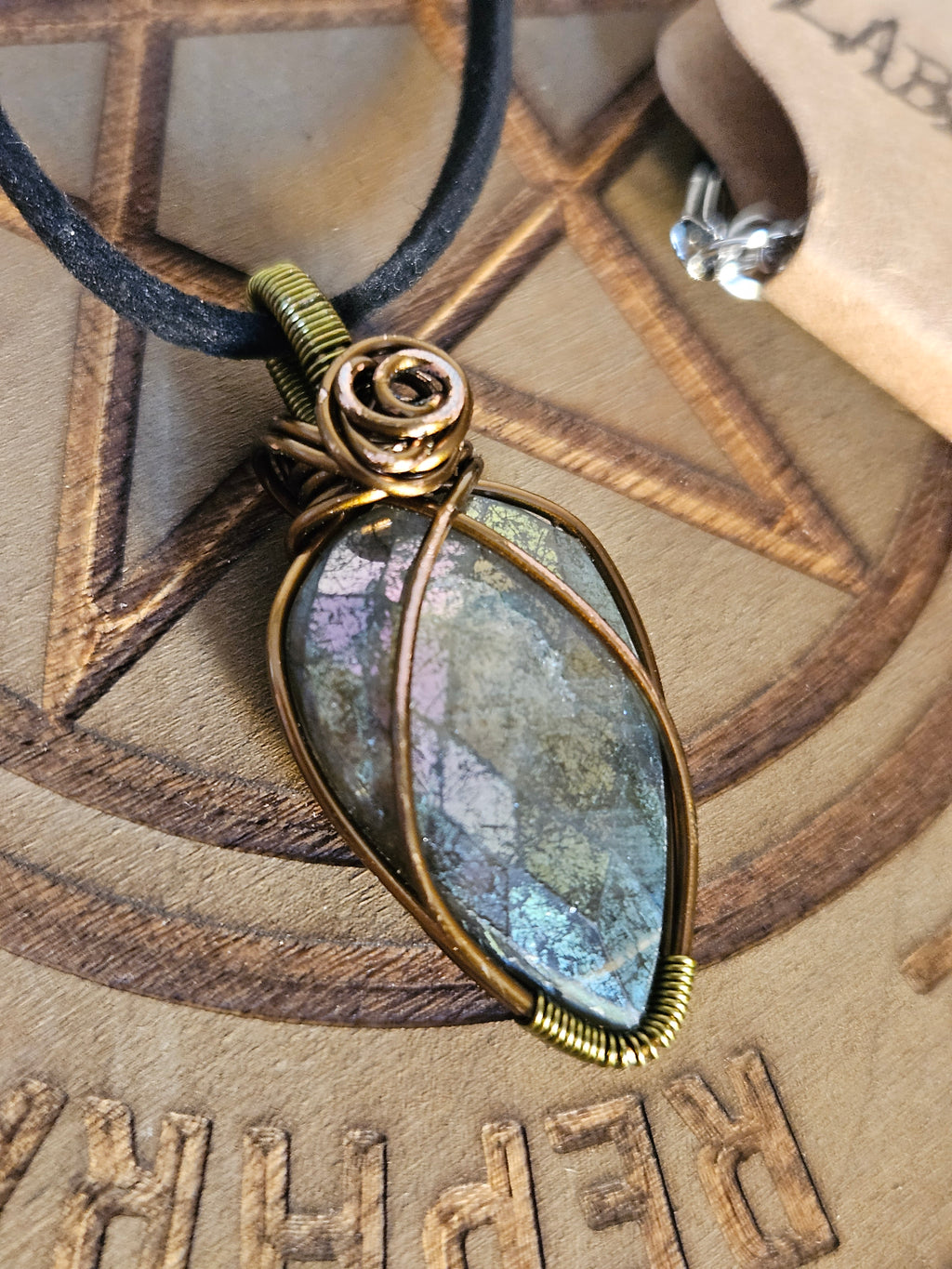 Wire wrapped crystal pendant on a wooden board