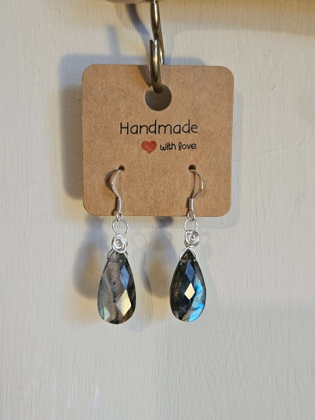 Pair of earrings with teardrop-shaped crystals on a 'Handmade with Love' card.