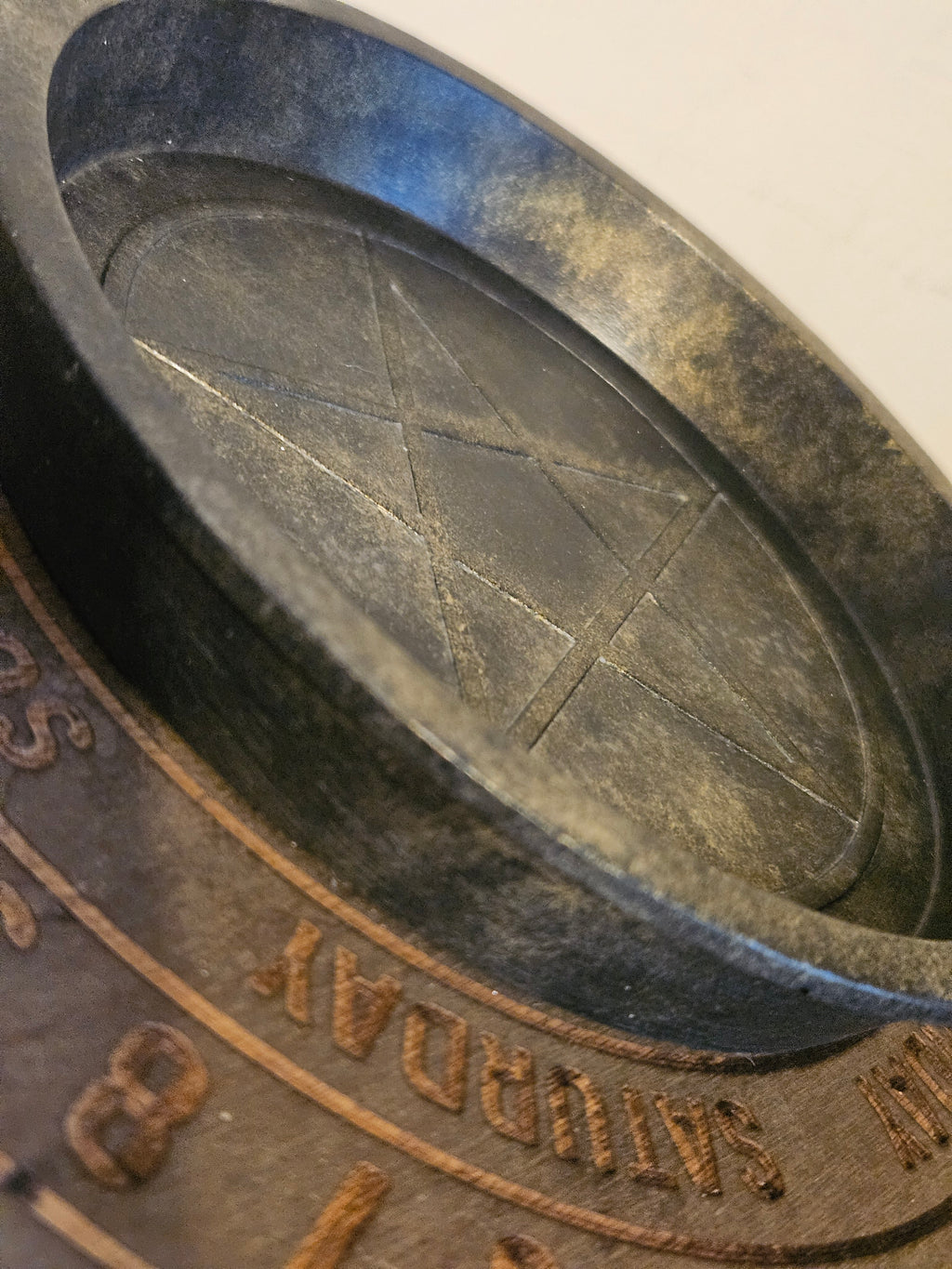 Close up of black and gold bowl with a pentagram