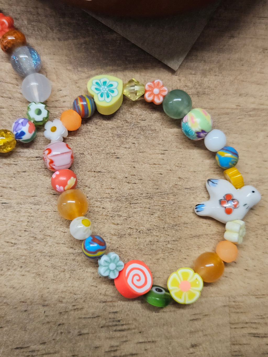 Colorful beaded bracelet with a star-shaped charm on a textured surface