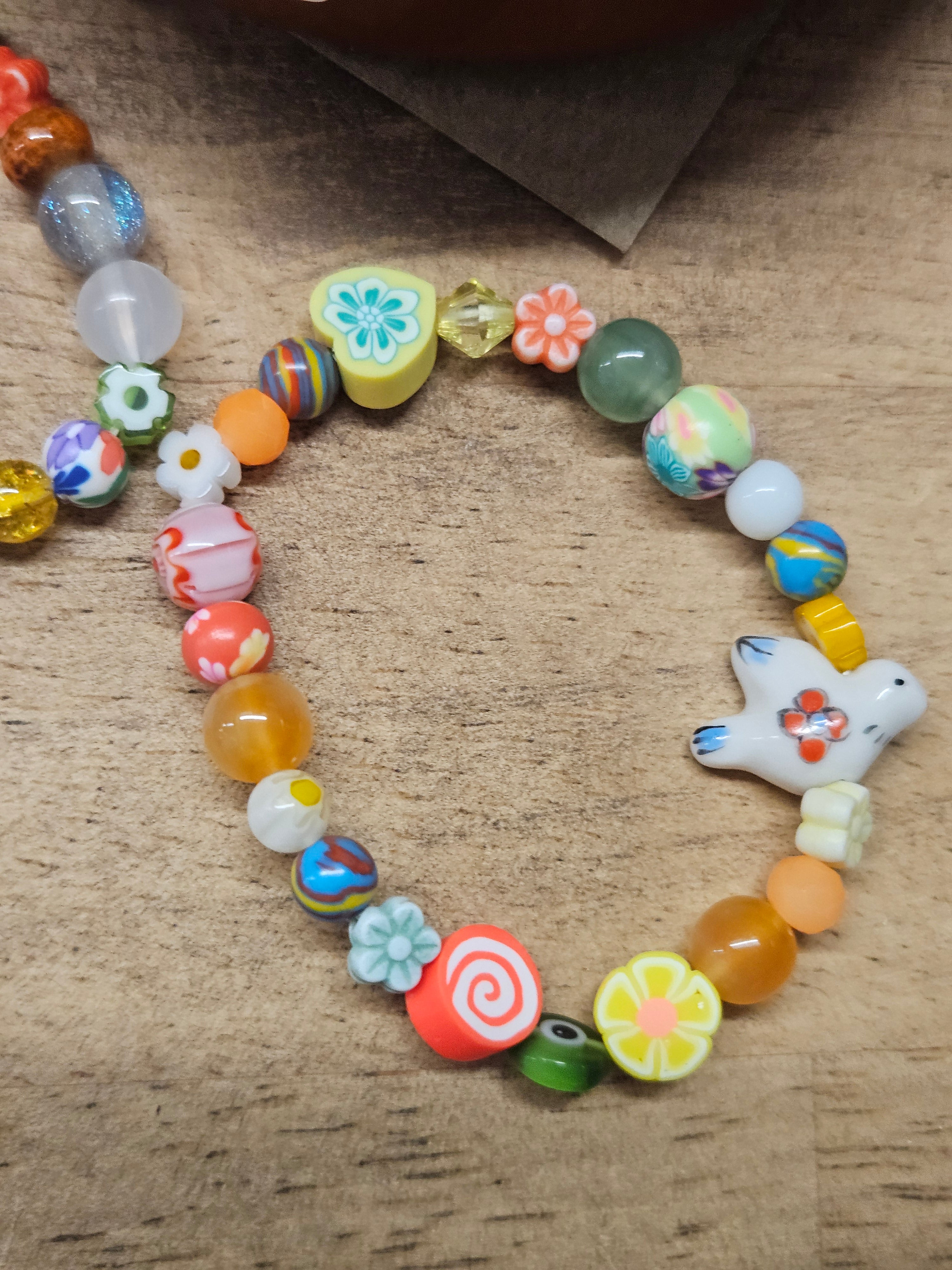 Colorful beaded bracelet with a star-shaped charm on a textured surface