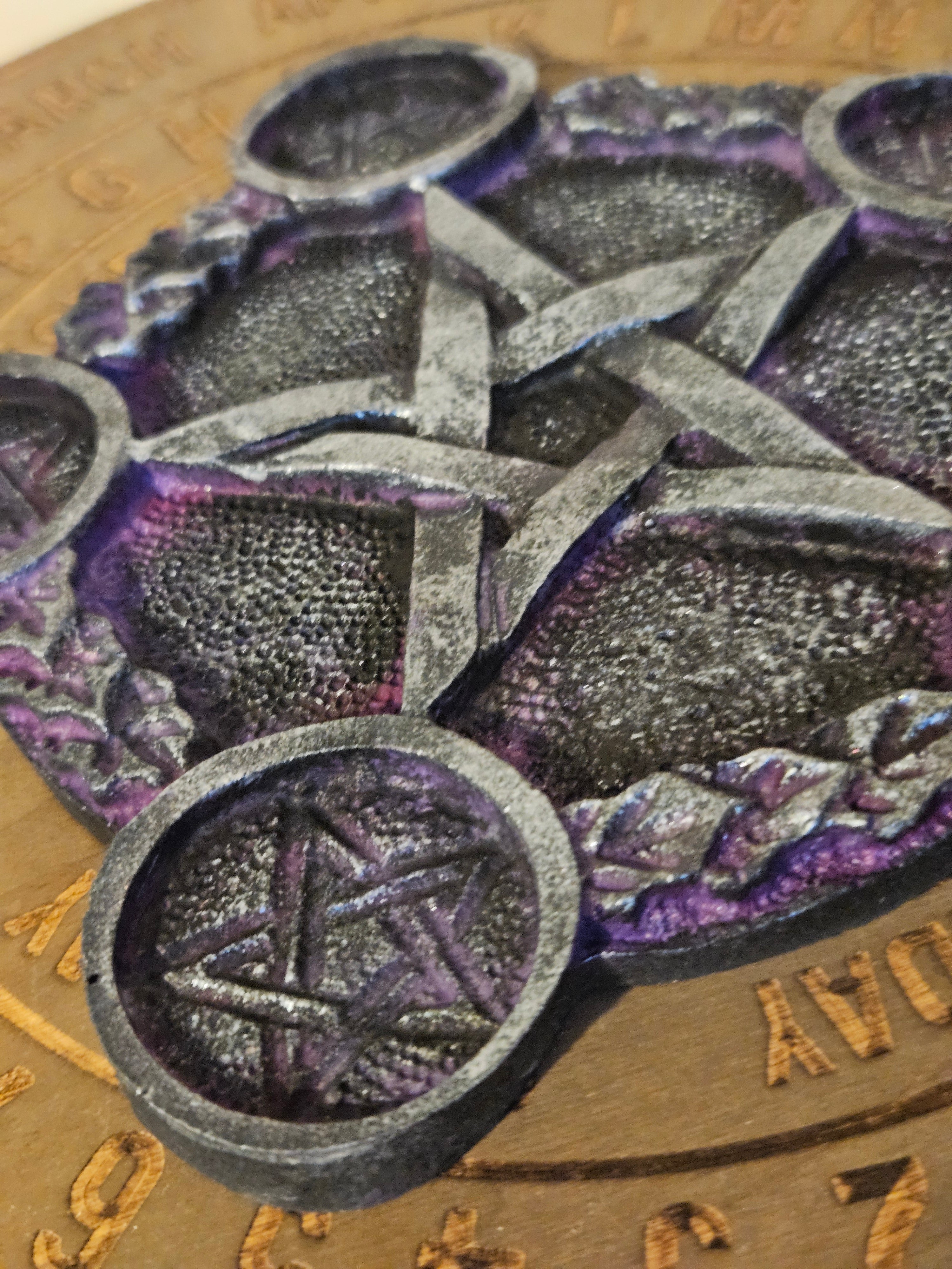 Close-up of metallic pentacle tea light holder with a textured background