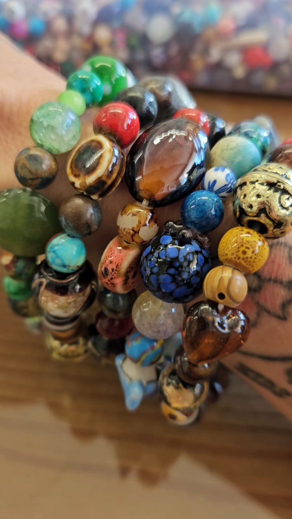 Stack of colorful beaded bracelets on a hand with a blurred background