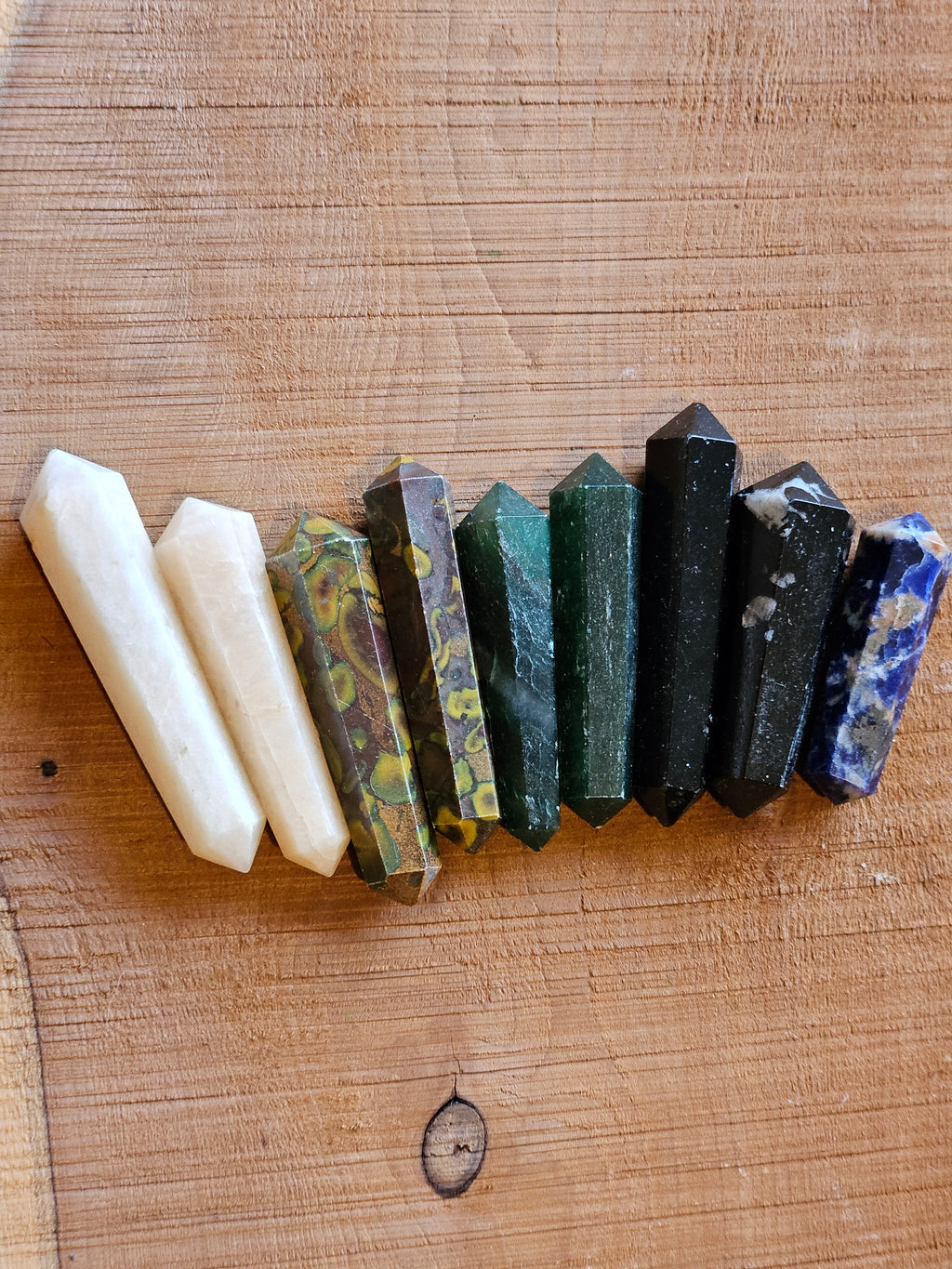 Row of various crystal points on a wooden surface