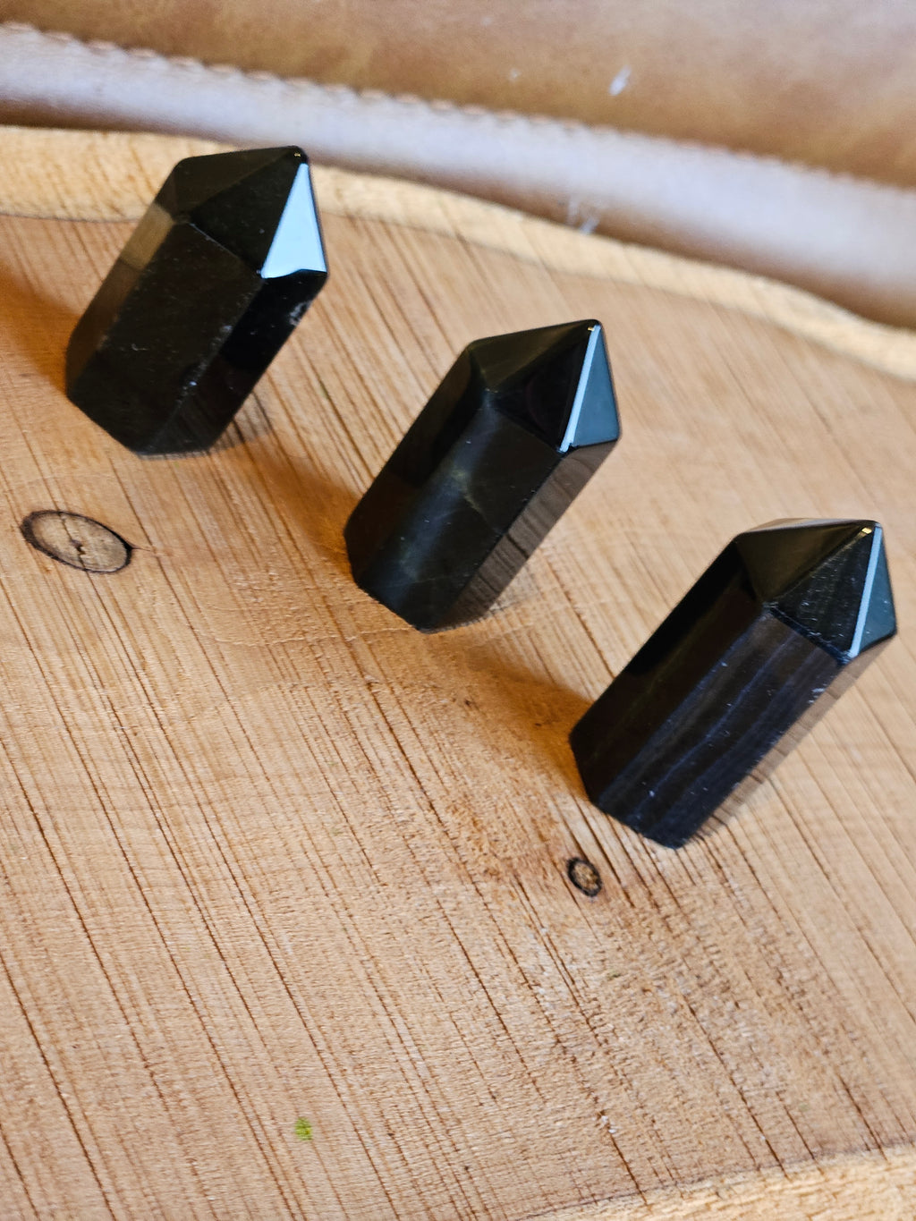 Three Blue Tigers Eye points on a wooden board