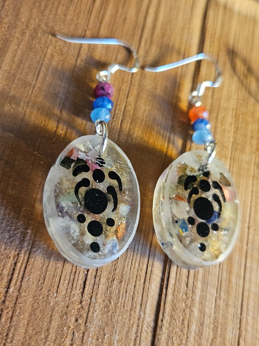 Pair of earrings with pattern design on a wooden surface