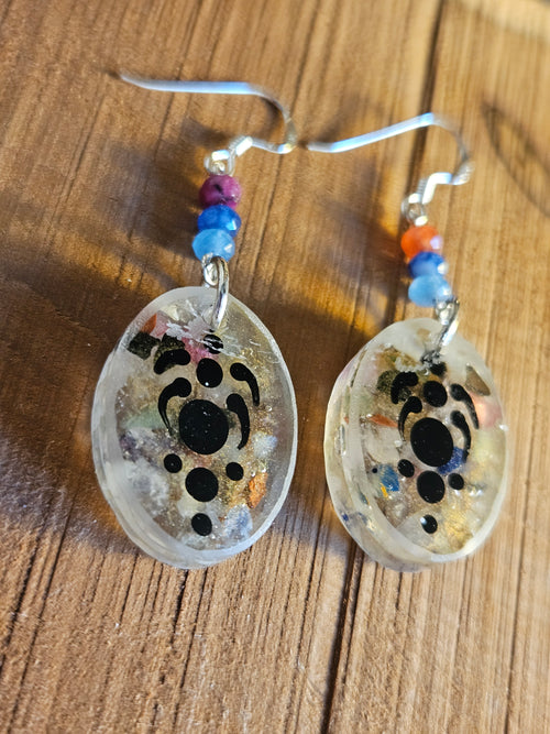 Pair of earrings with pattern design on a wooden surface