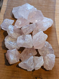 Pile of Rose Quartz chunks on a wooden board