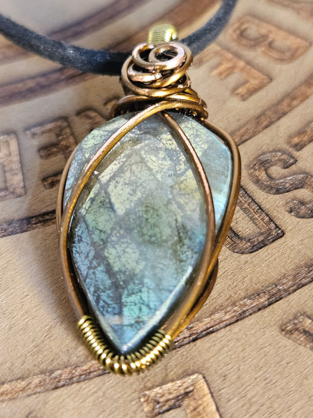 Close up of Labradorite pendant showing faceted detail and wire work
