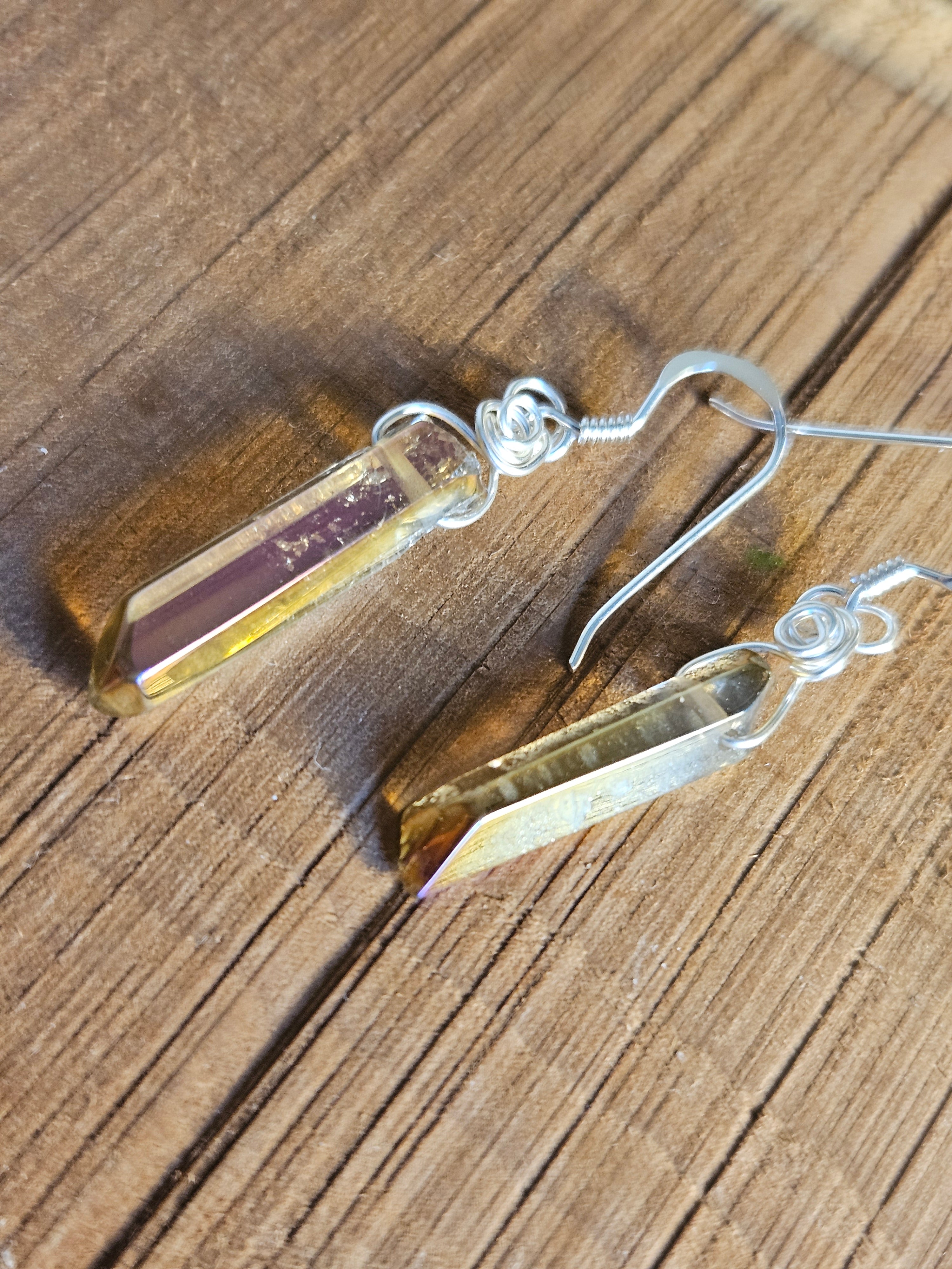 Gold crystal earrings on a wooden surface