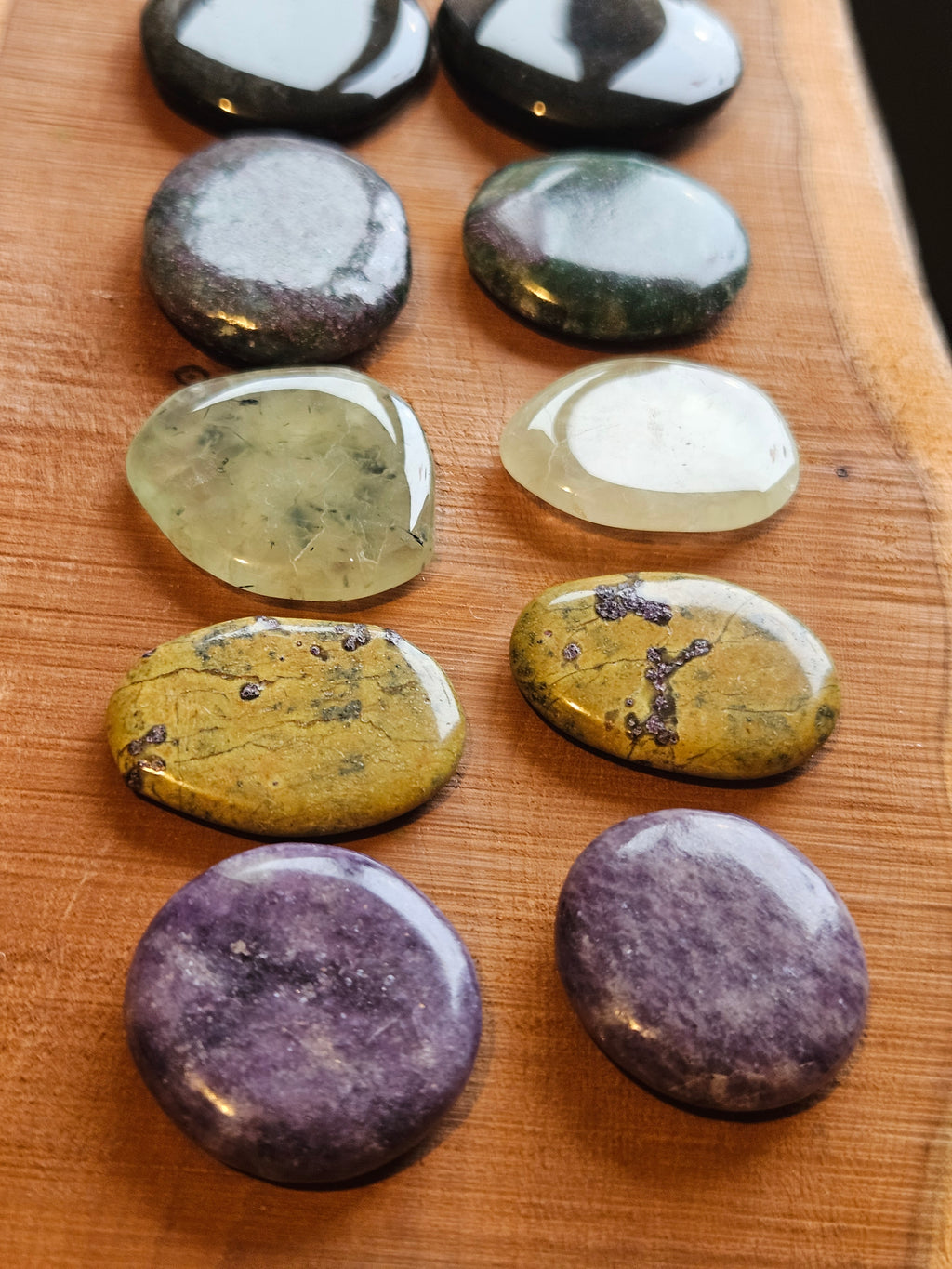 Collection of multicolored smoothstones on a wooden surface