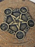 Black and gold pentagram tea light holder on a wooden board