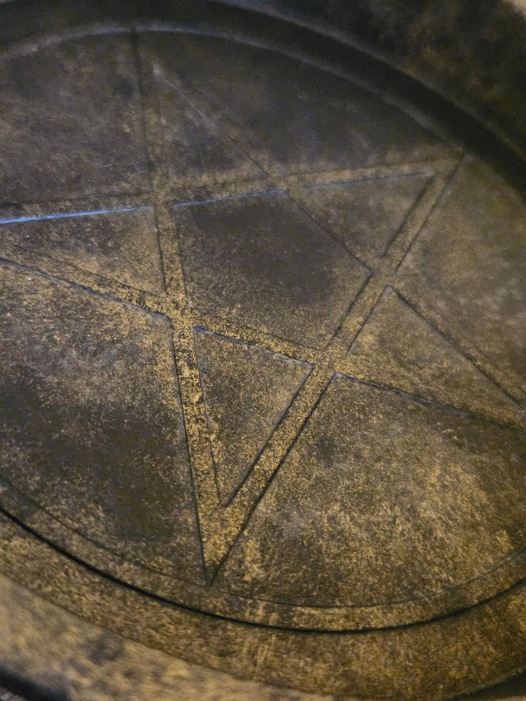 Close up of black and gold pentagram