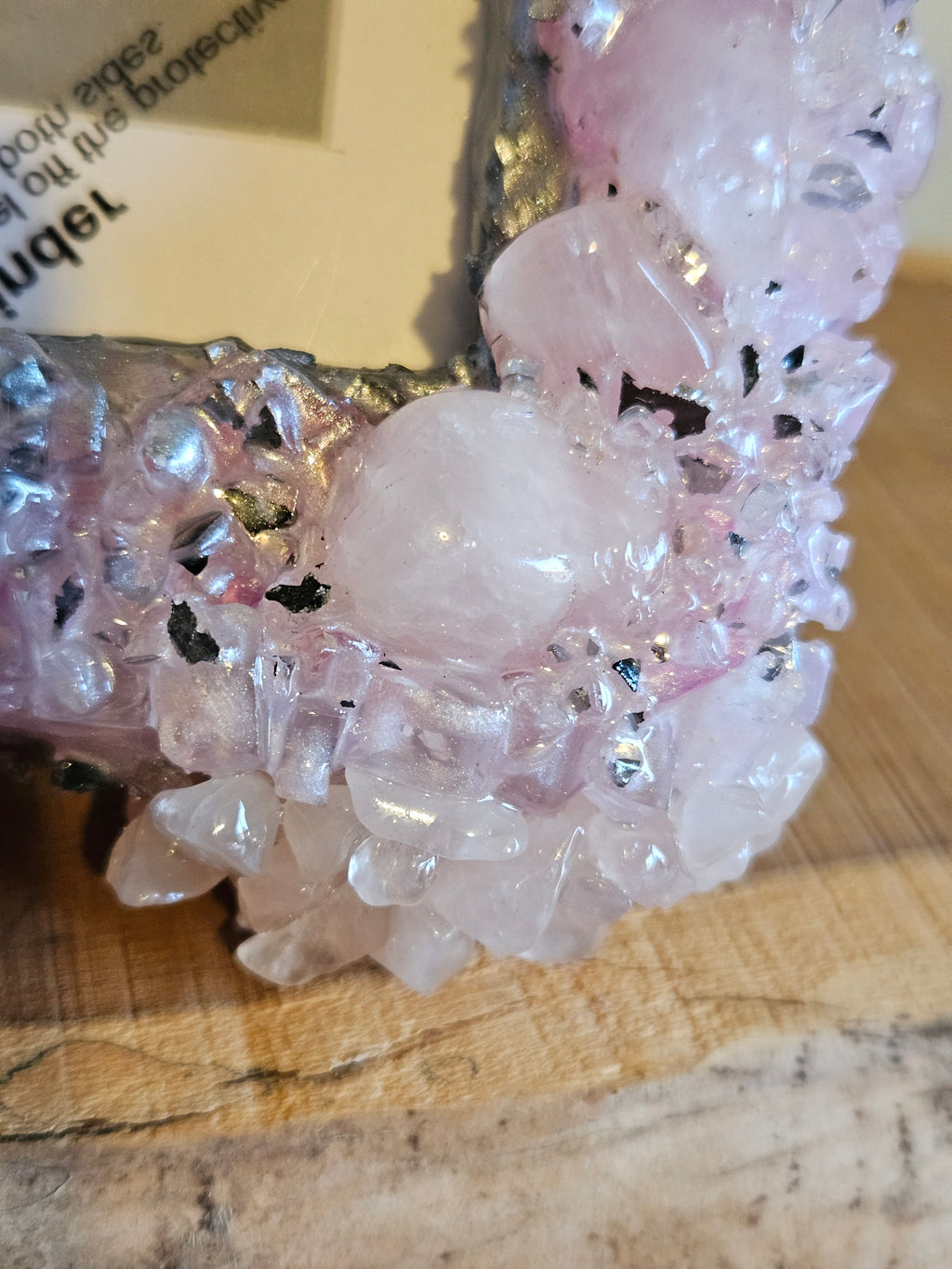 Close-up of a pink crystal photo frame on a wooden surface