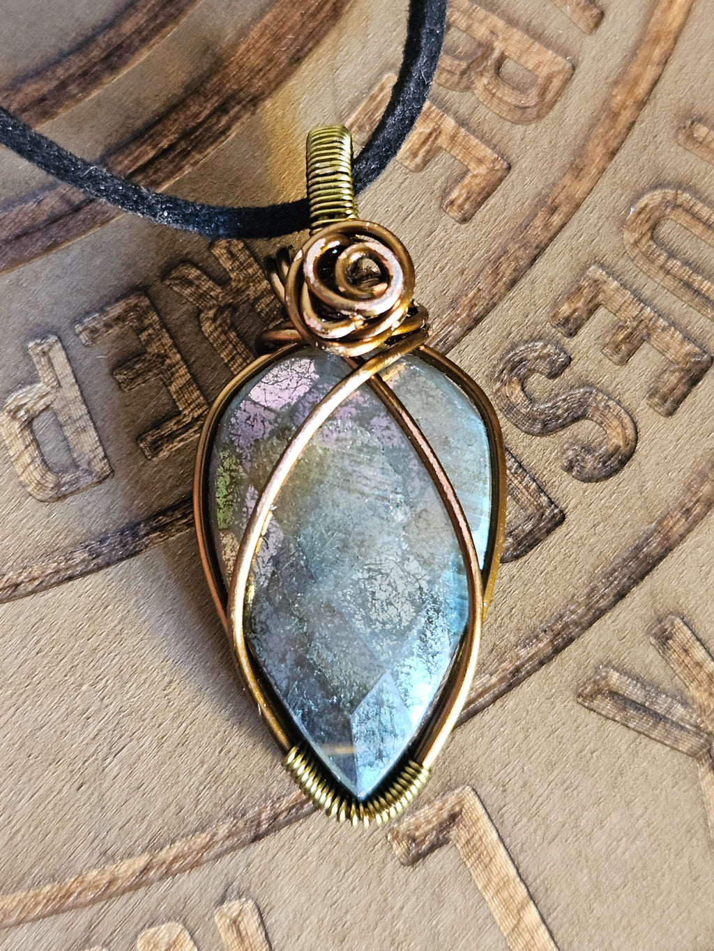 Bronze pendant with a large gemstone on a textured background