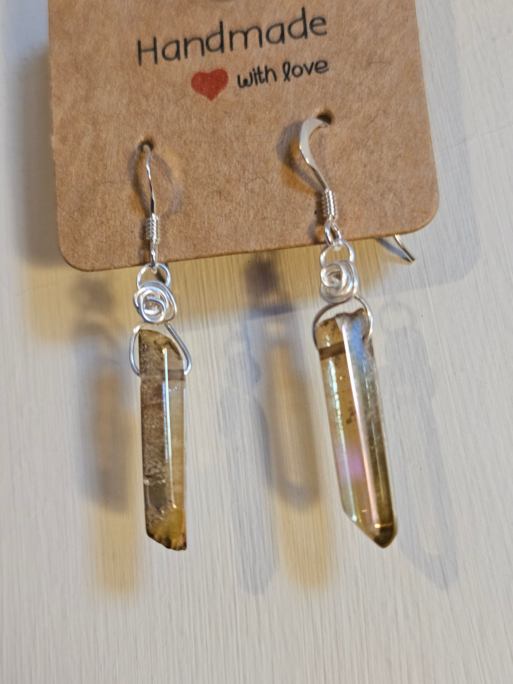 Crystal earrings on a 'Handmade with Love' card against a light background