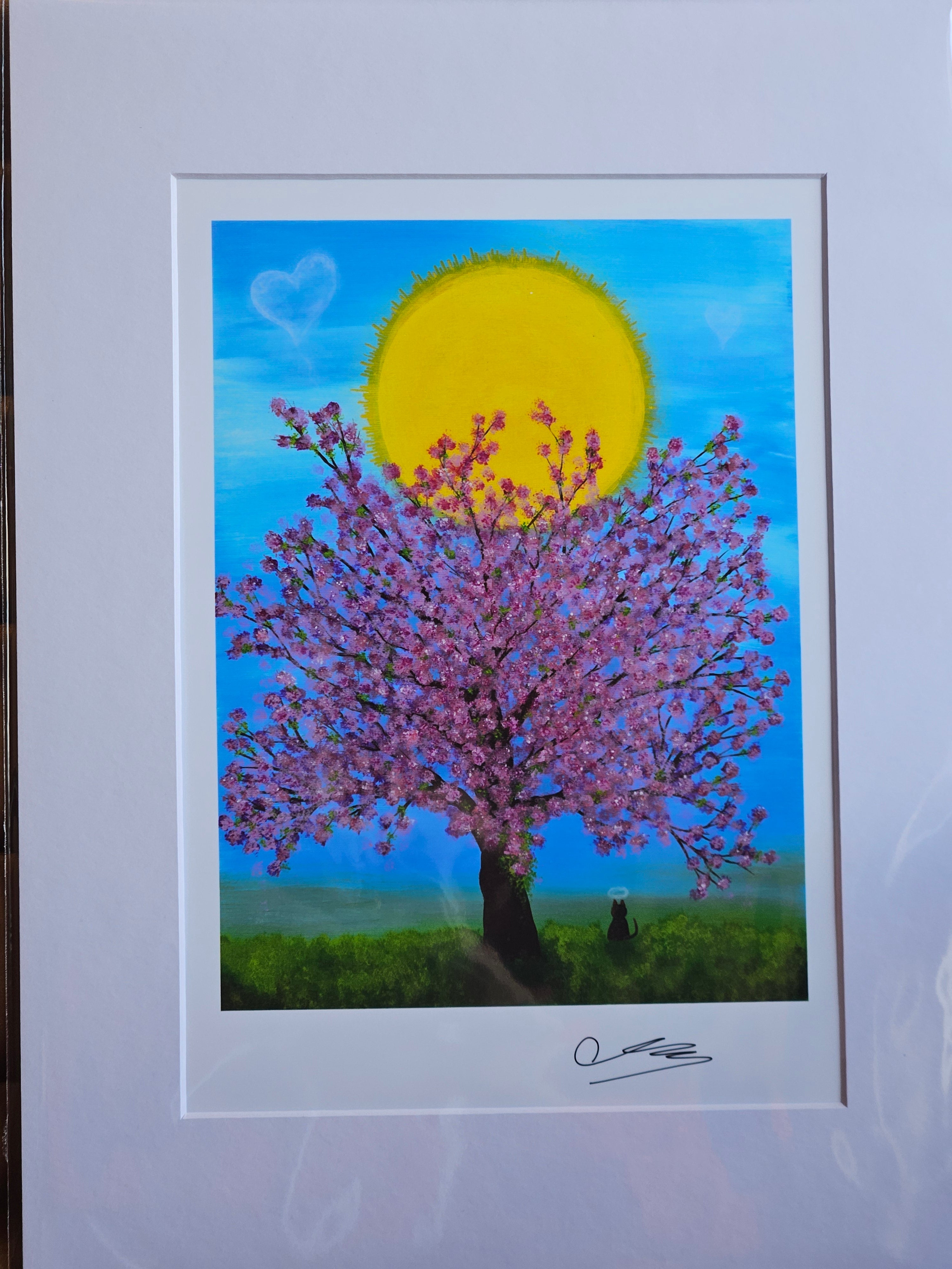 Framed artwork of a tree with pink blossoms against a blue sky with a yellow sun.