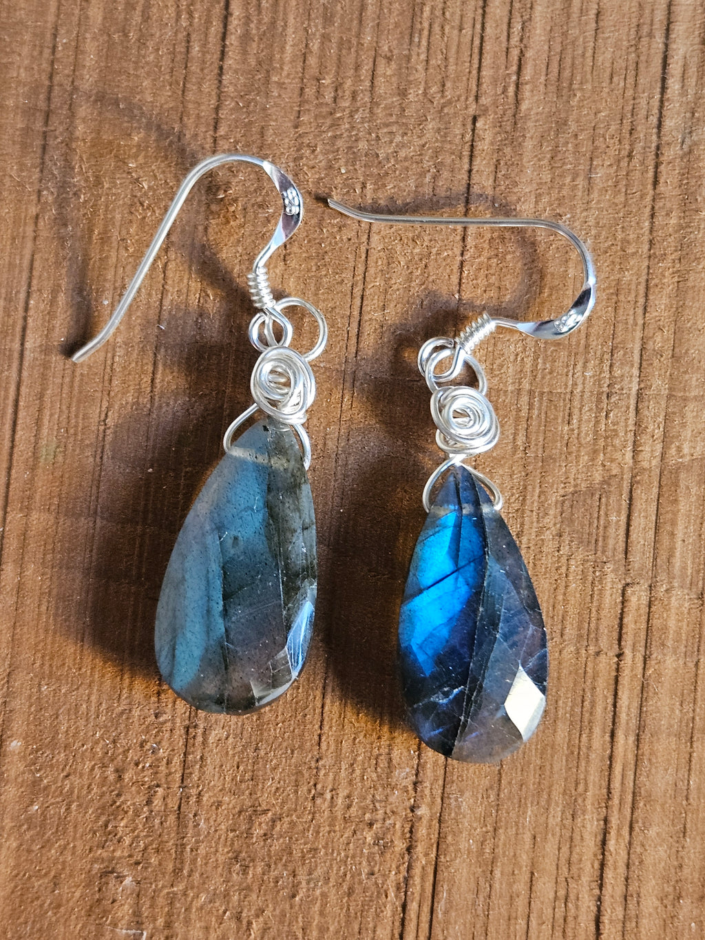 Blue teardrop earrings on a wooden surface