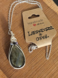 Labradorite opal necklace on a wooden surface with a branded card.
