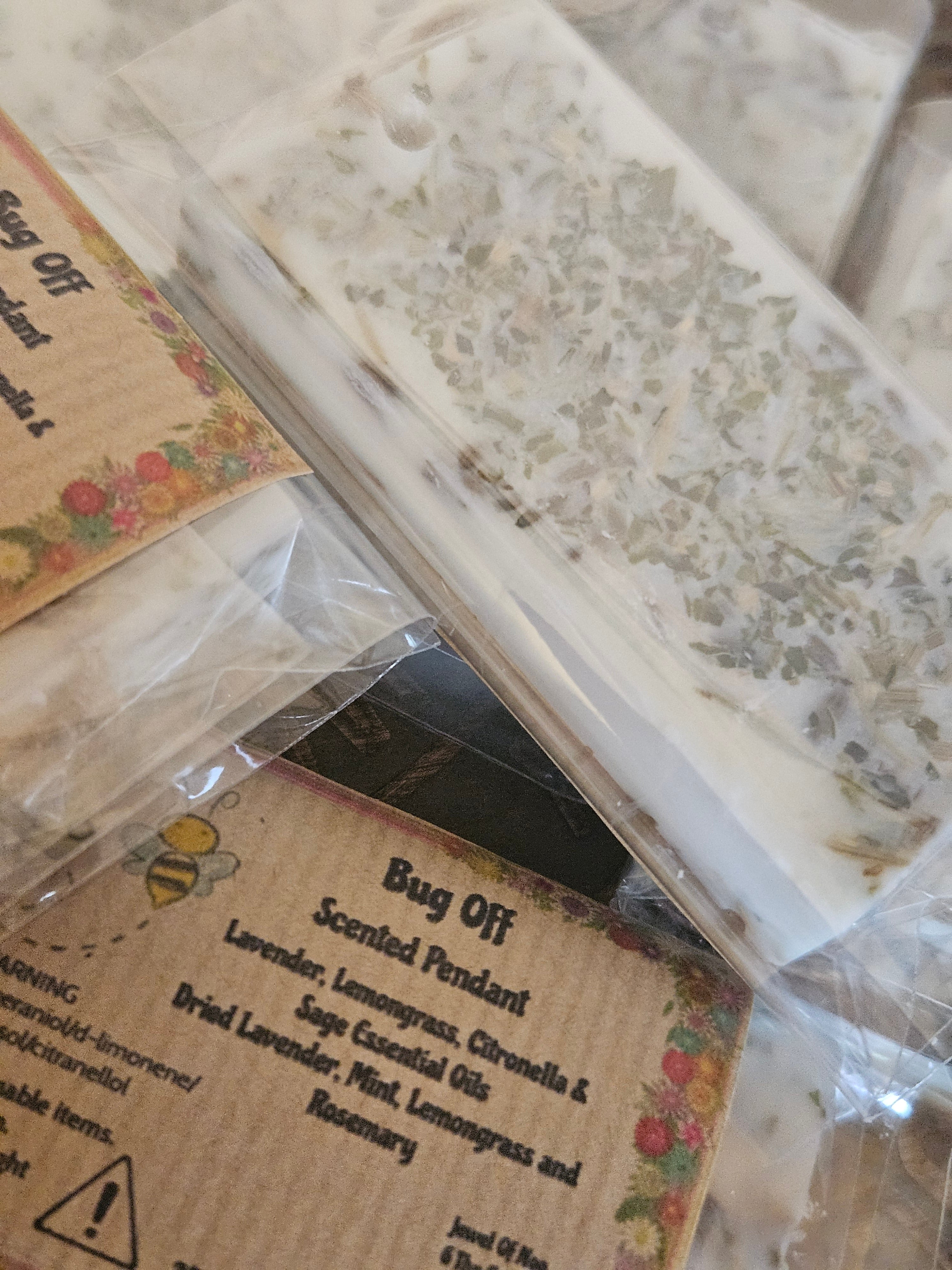 Bug off scented pendant with floral label and transparent packaging