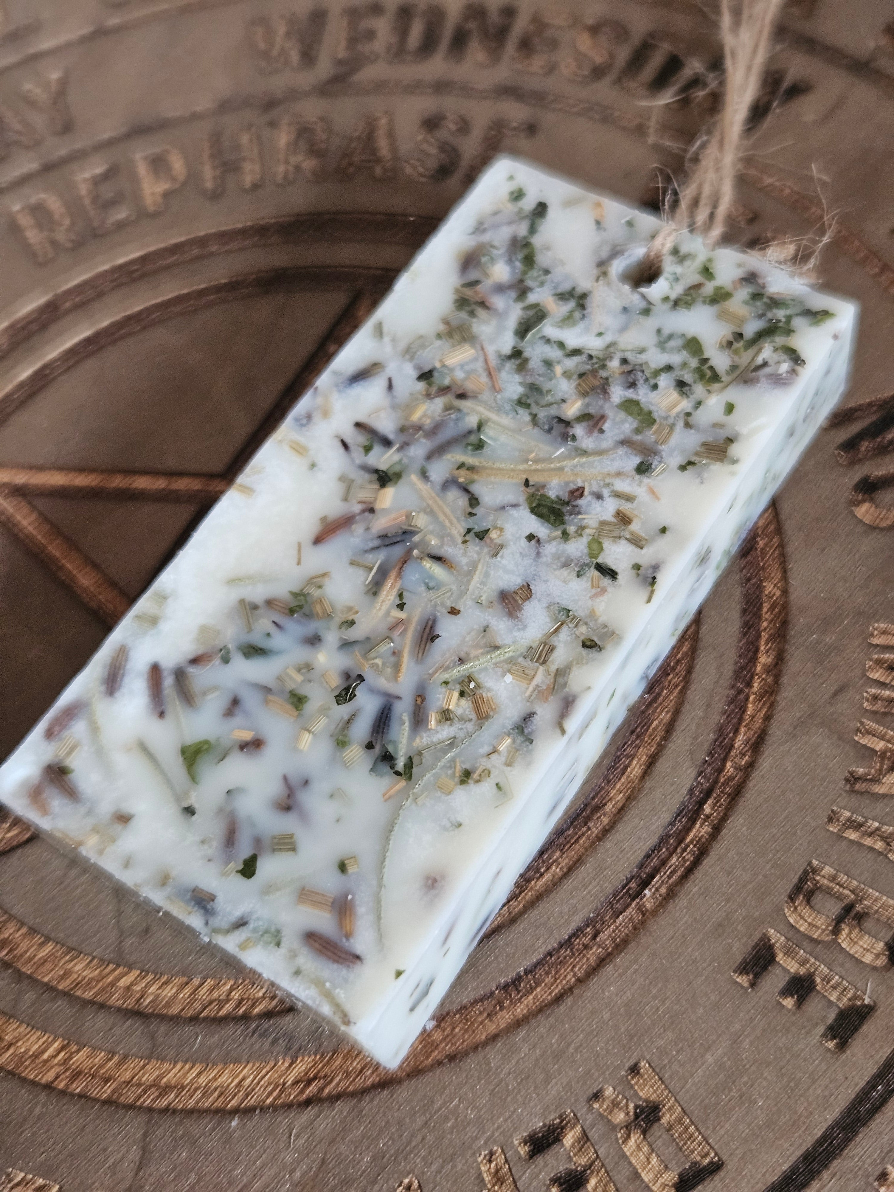 Rectangular scented pendant with natural ingredients on a textured surface