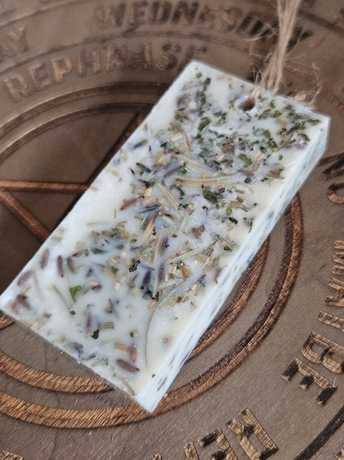 Rectangular scented pendant with natural ingredients on a textured surface