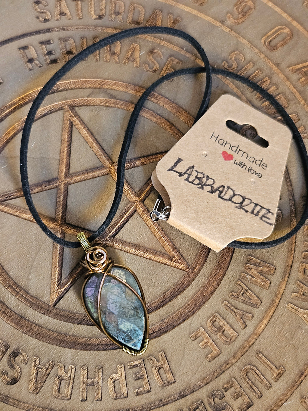 Labradorite pendant on a wooden surface