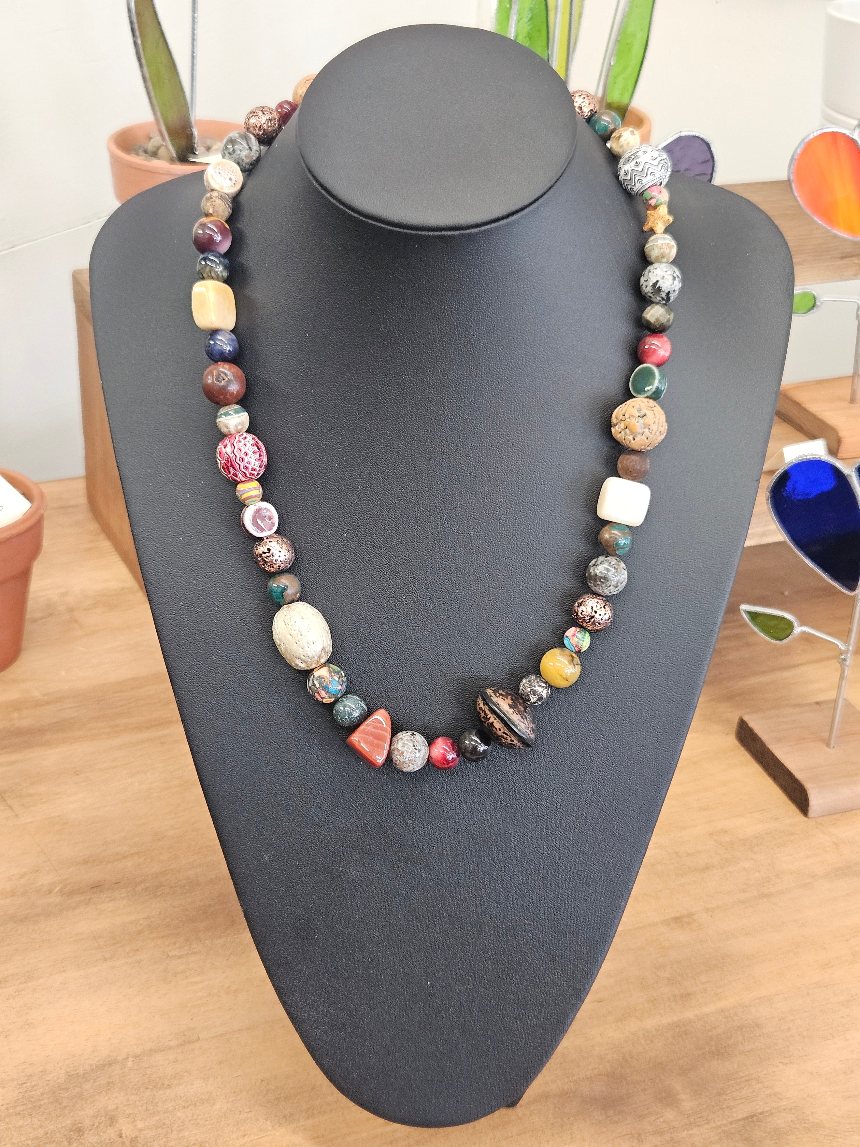Necklace on a black mannequin bust with a blurred indoor background