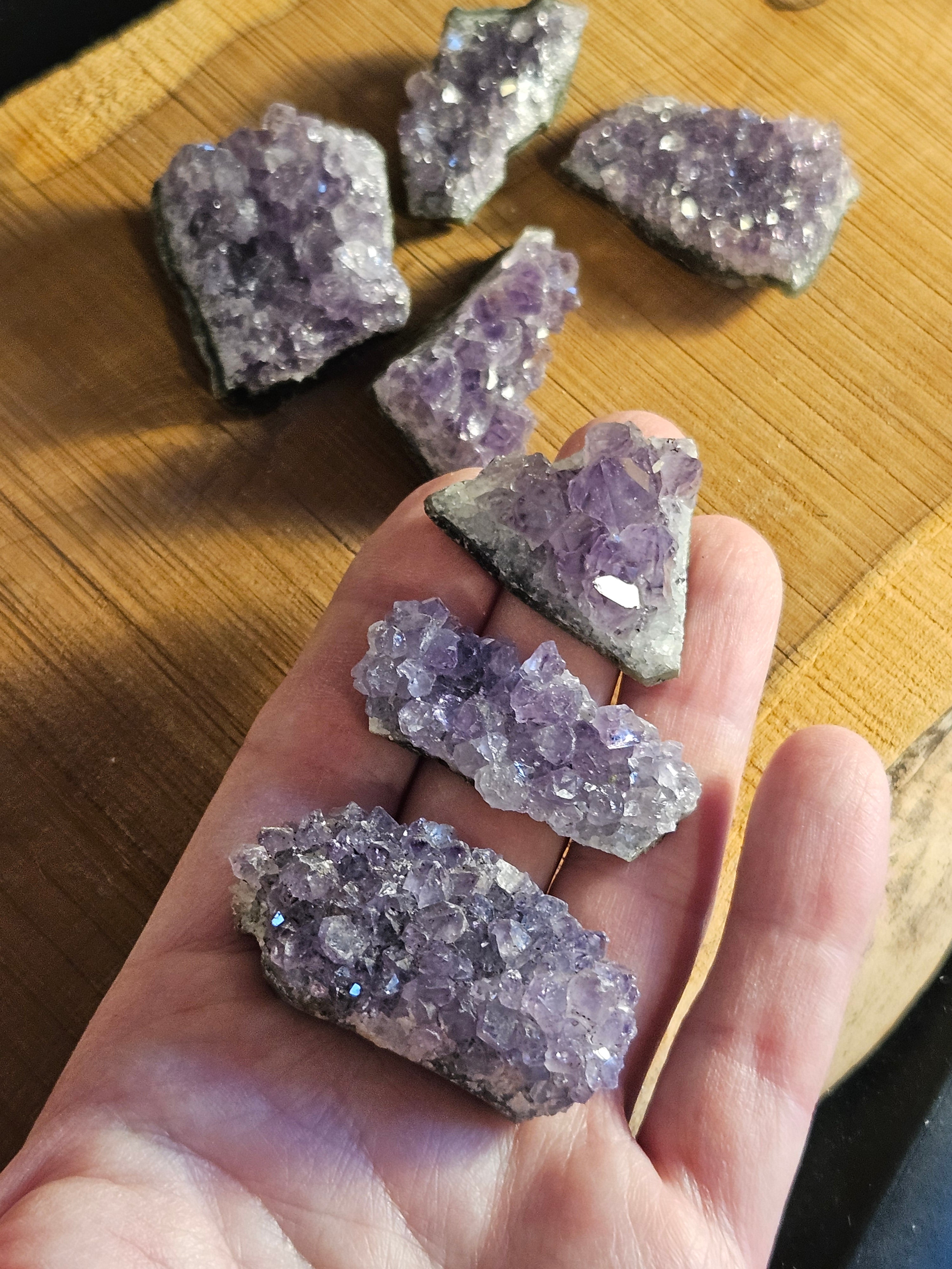Mini Amethyst clusters in a hand to show size