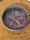 Close-up of a circular object with a star design and gold text around the edge.