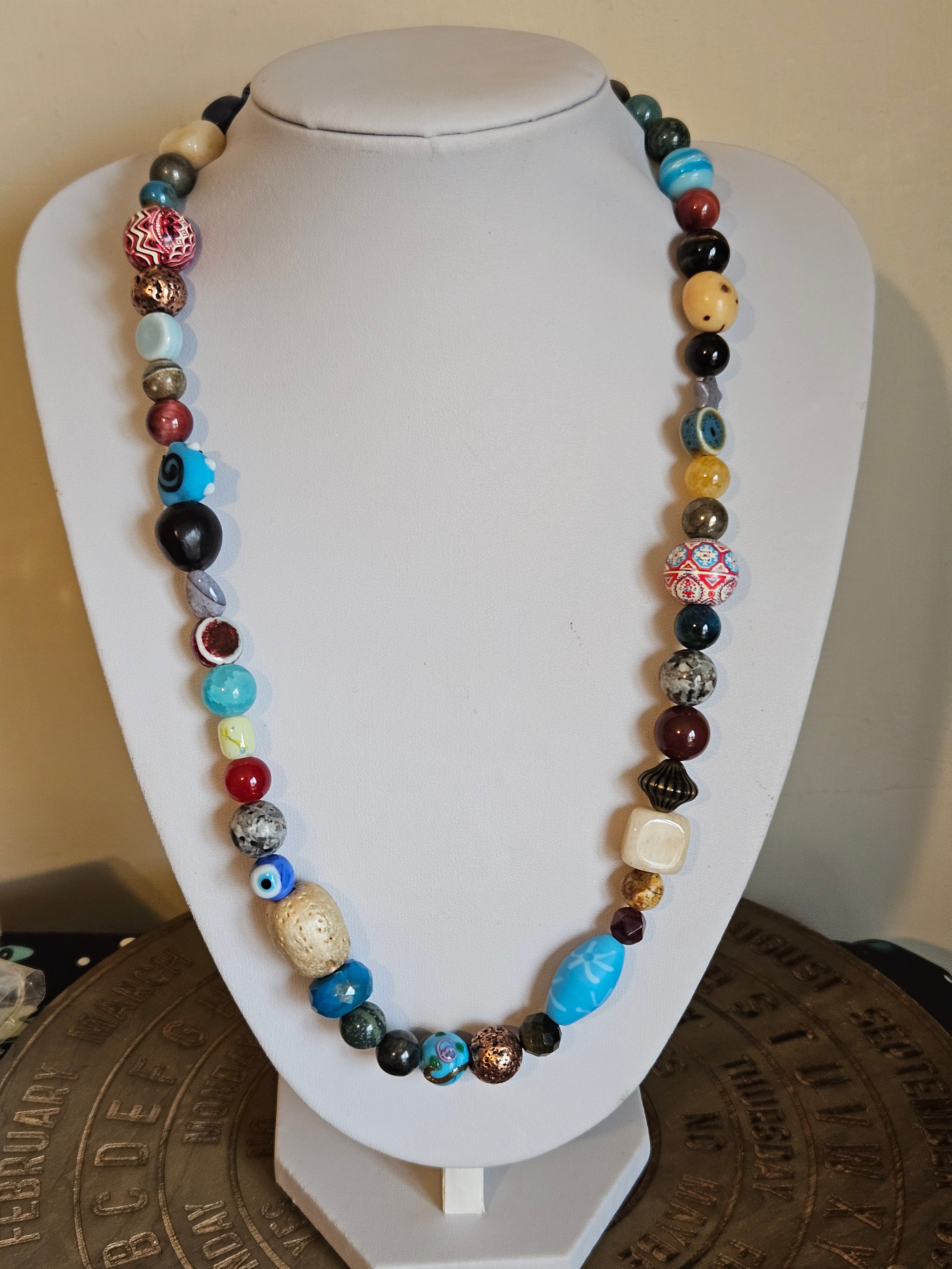 Colorful beaded necklace on a white mannequin bust.
