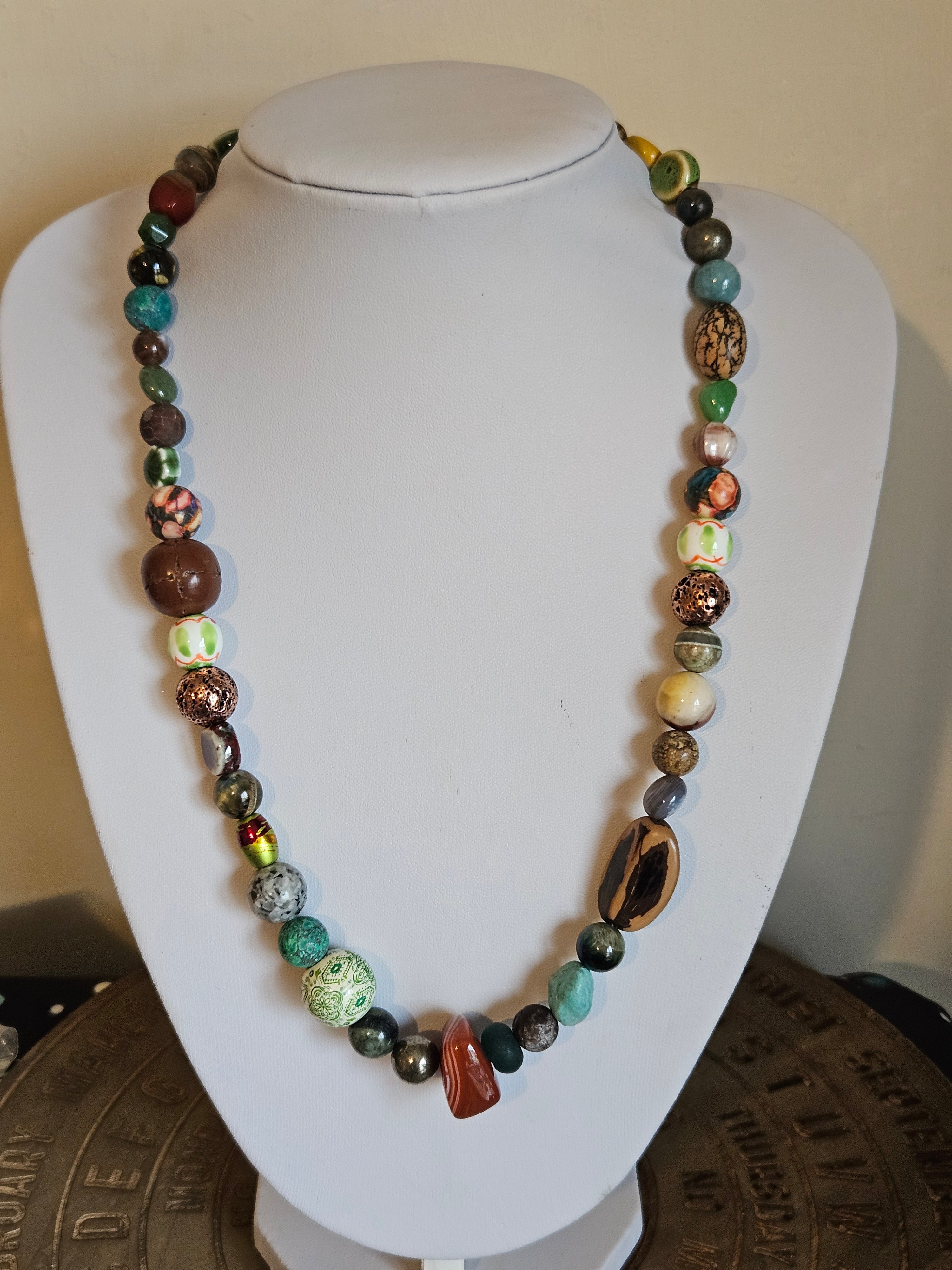 Multicolored beaded necklace on a white mannequin bust.