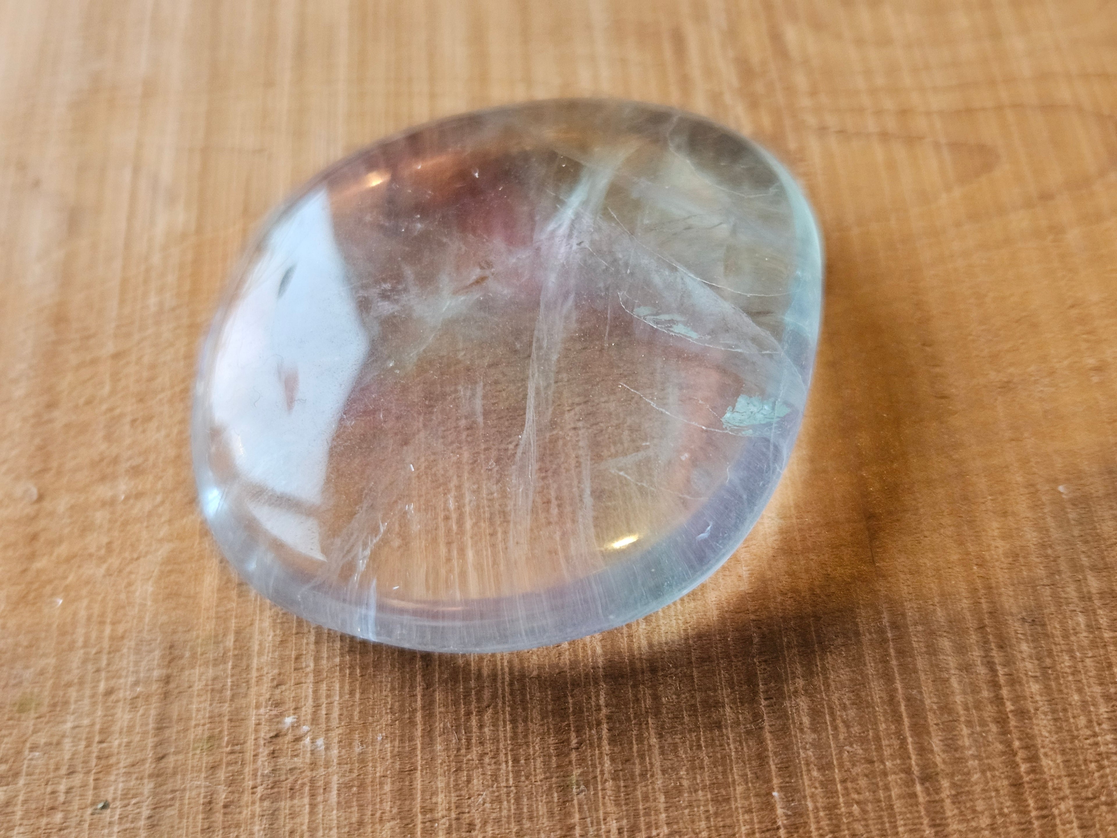 Fluorite  smoothstone on a wooden surface