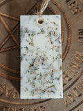Rectangular scented pendant with natural ingredients on a textured surface